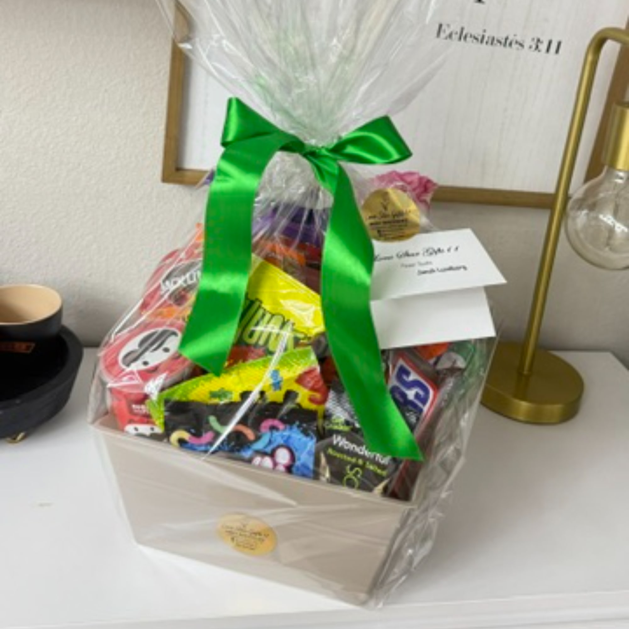 Gift basket of assorted candy in a white box with a green ribbon