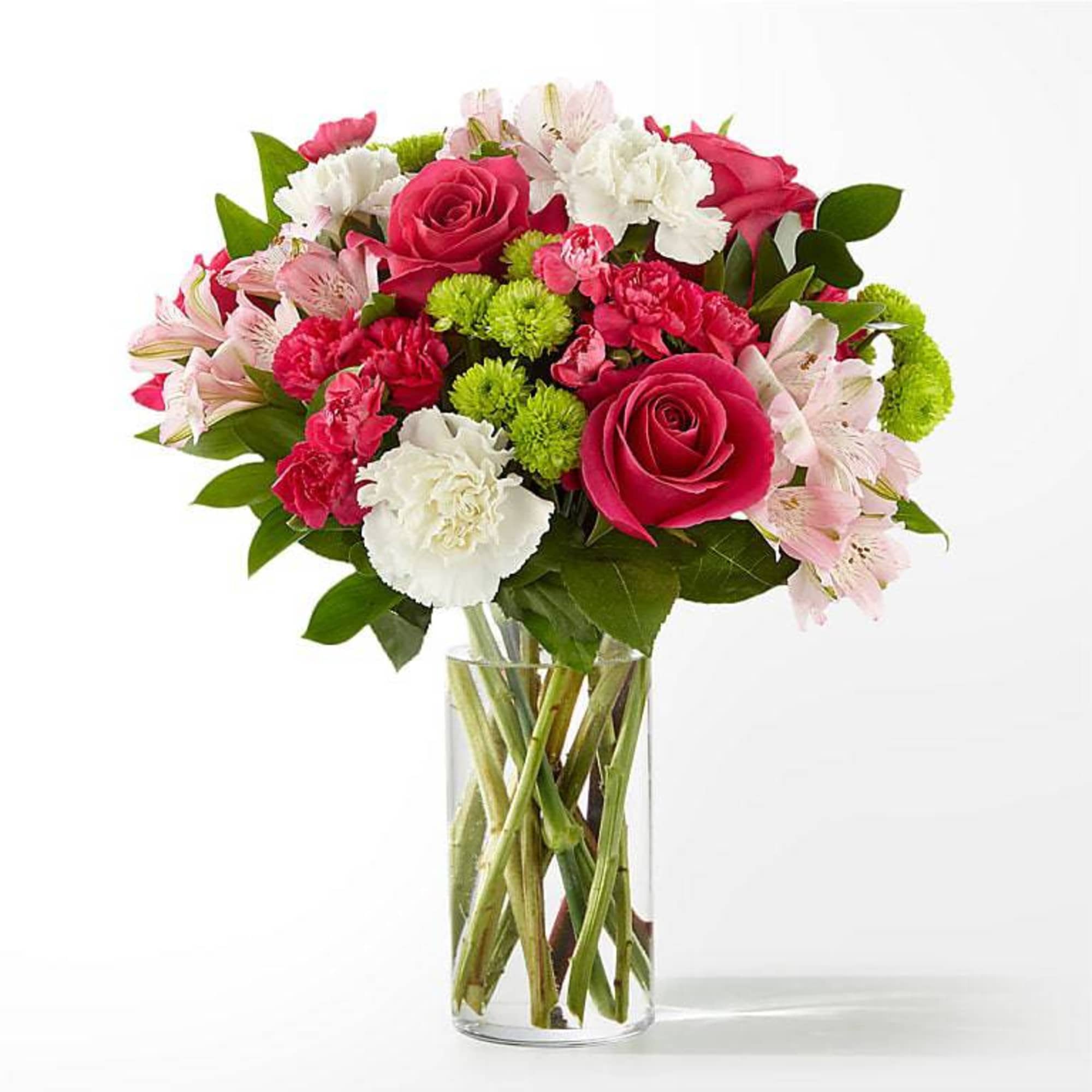Bouquet of pink roses, carnations, and white flowers in a clear glass vase