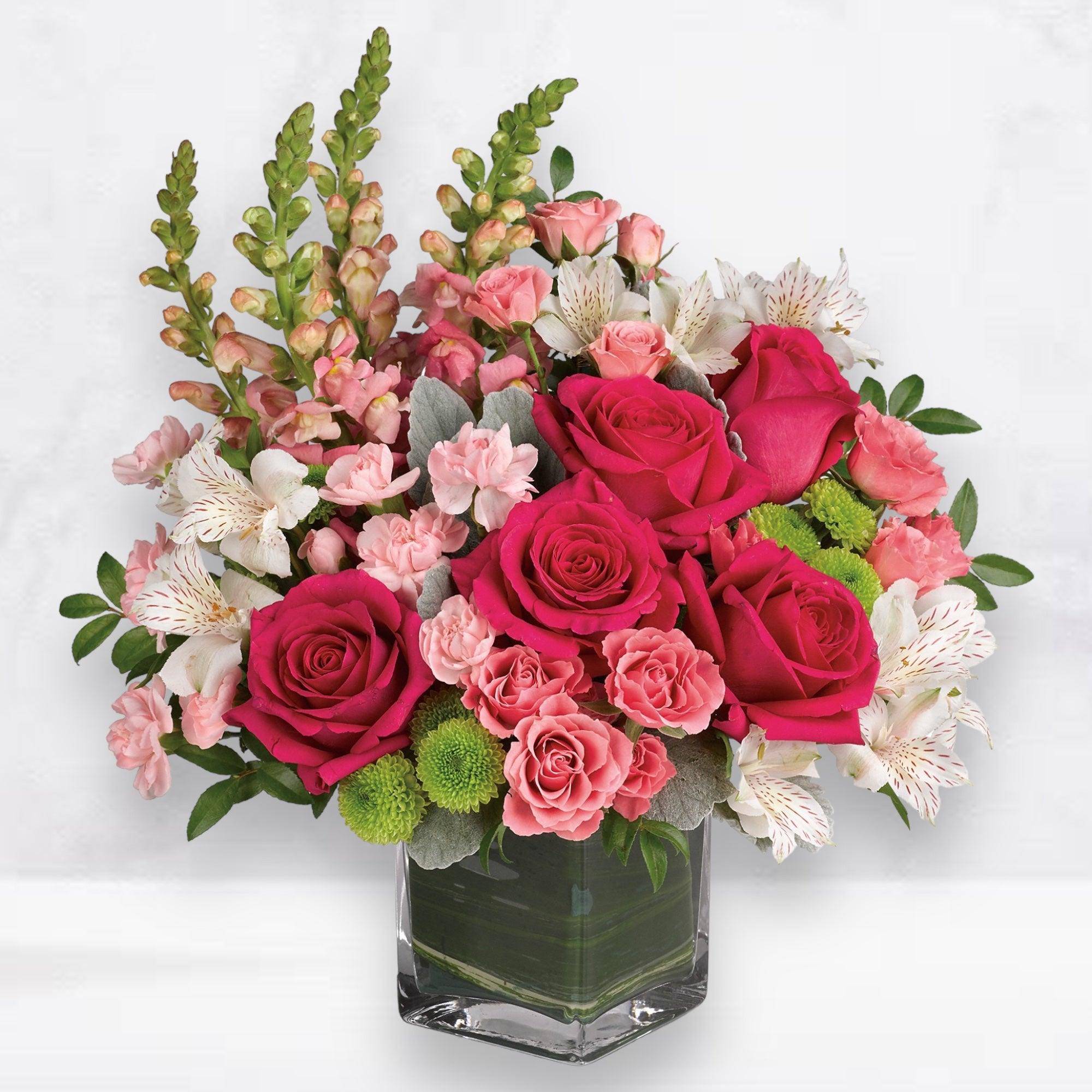 Pink roses and white alstroemeria in a square glass vase
