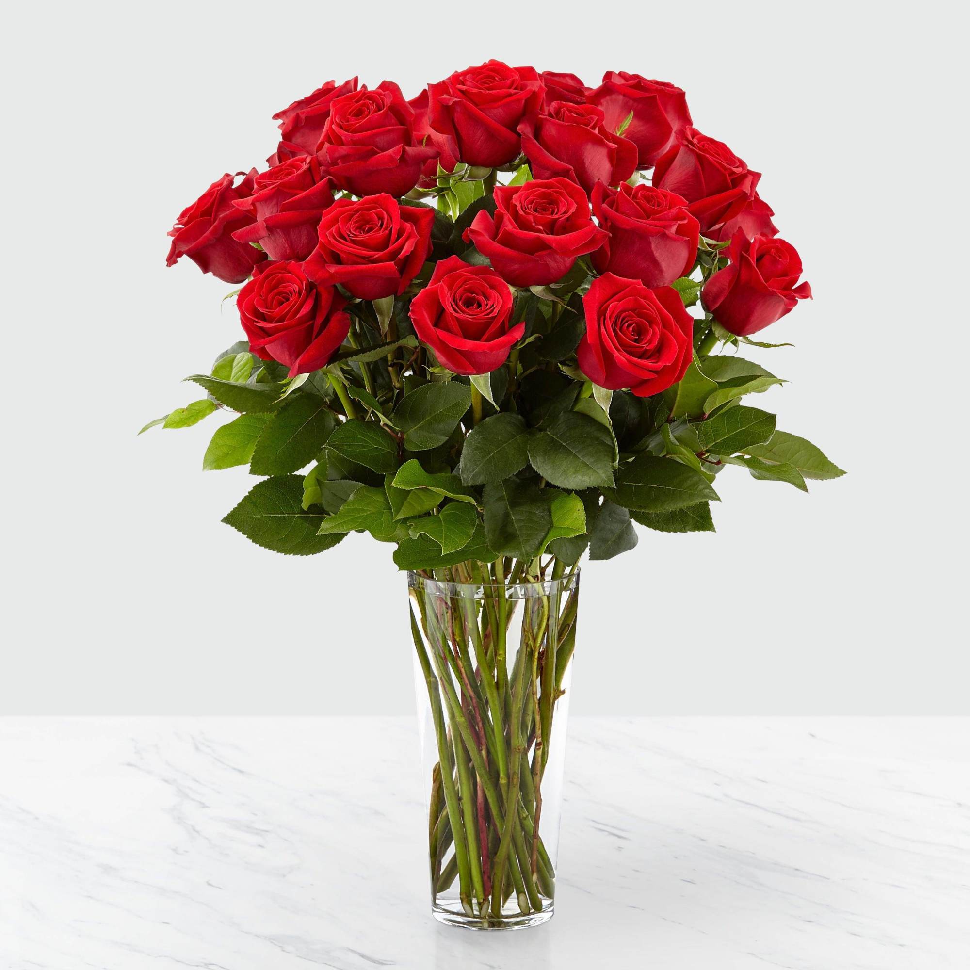 Red roses arranged in a clear glass vase