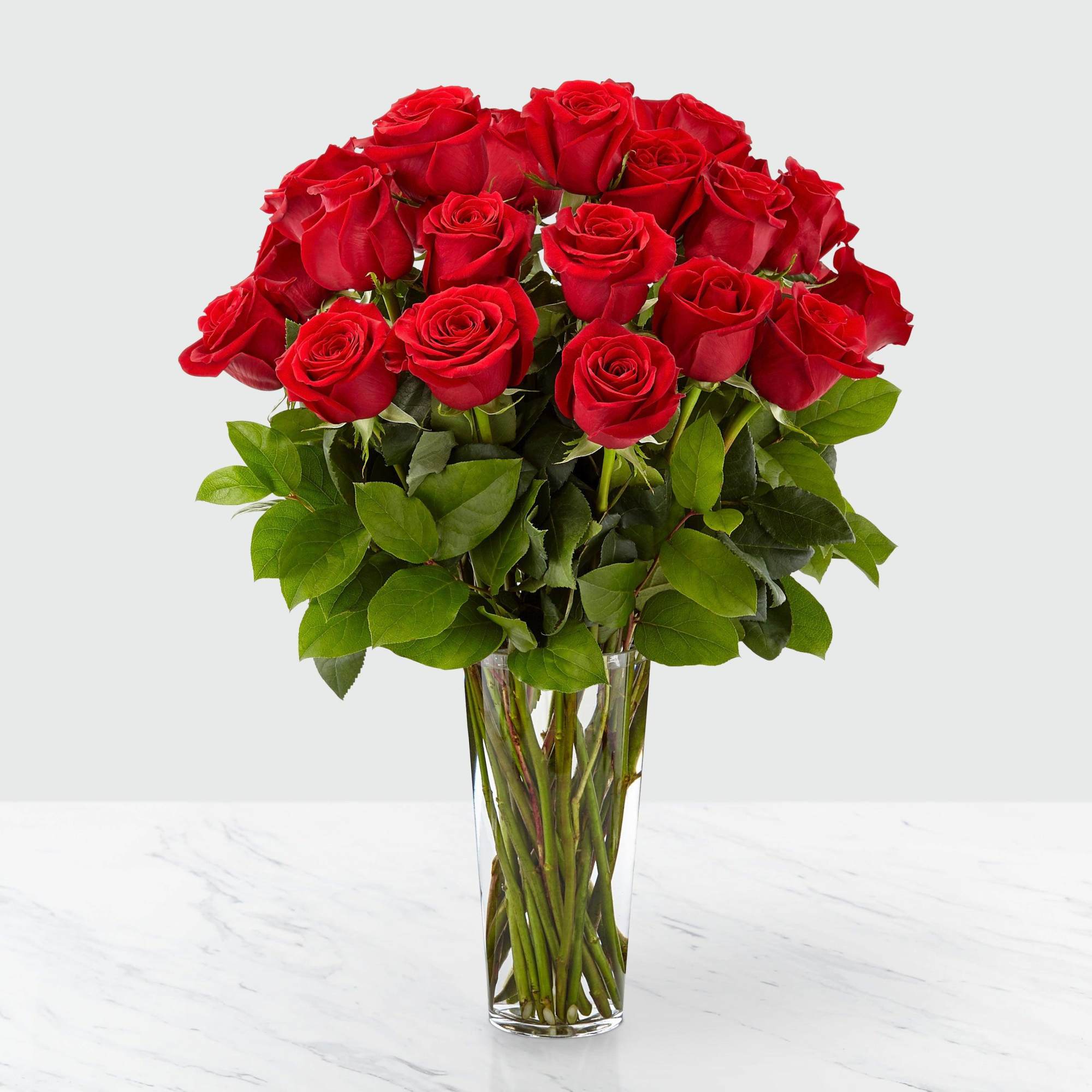 Red roses arranged in a clear glass vase