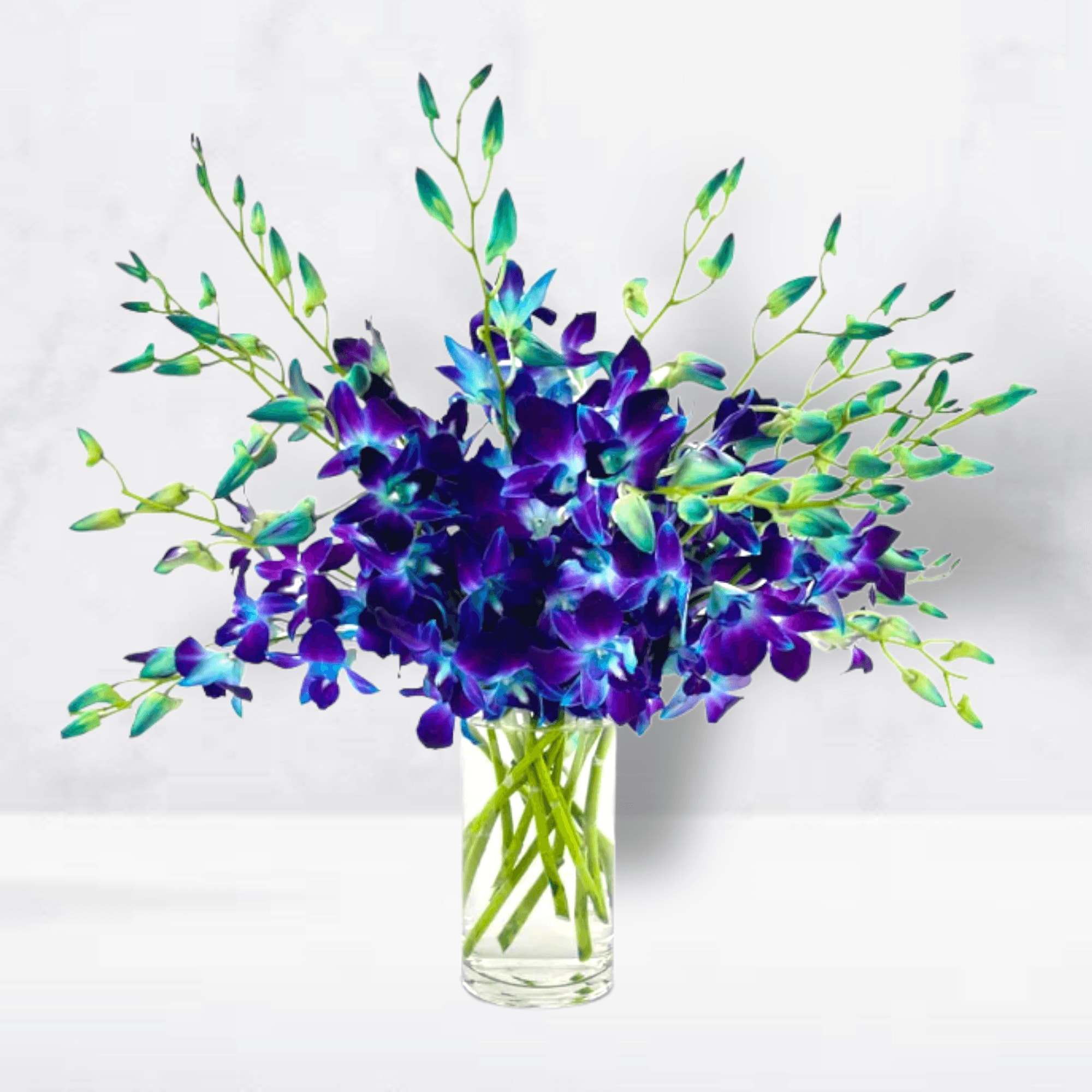 Purple and blue orchid arrangement in a clear glass vase