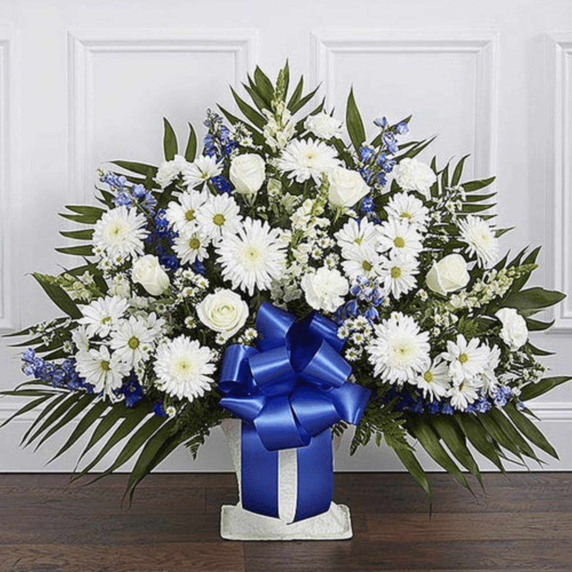 White and blue floral arrangement with a large blue ribbon