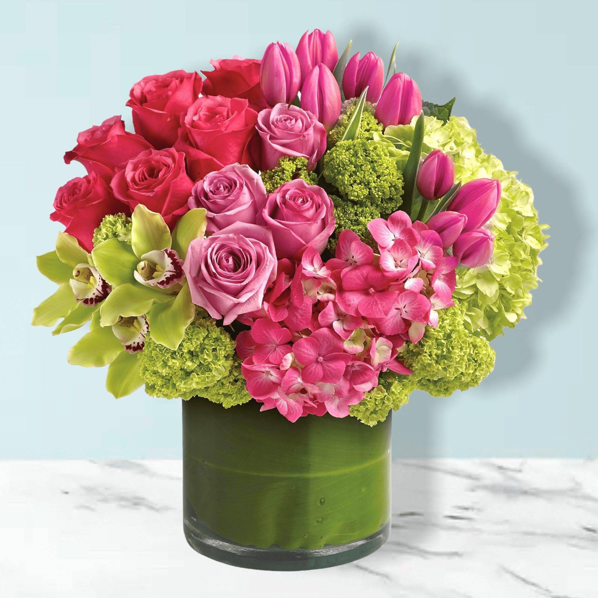 Pink roses and tulips in a green glass vase