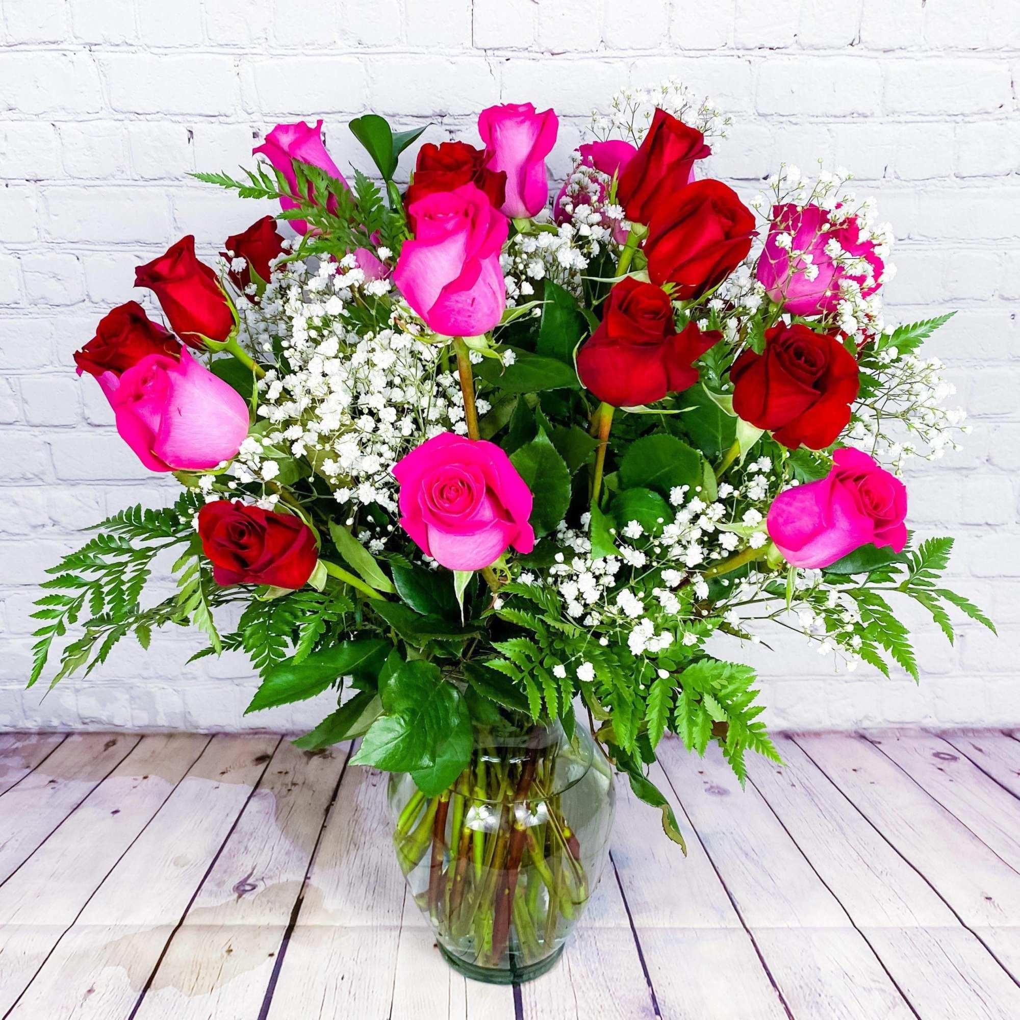 Bouquet of red and pink roses in a clear glass vase