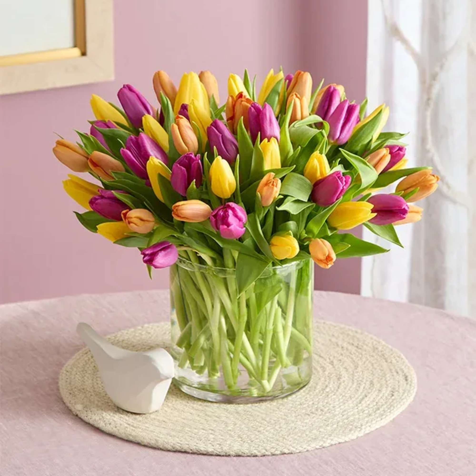 Bouquet of multicolored tulips in a clear glass vase
