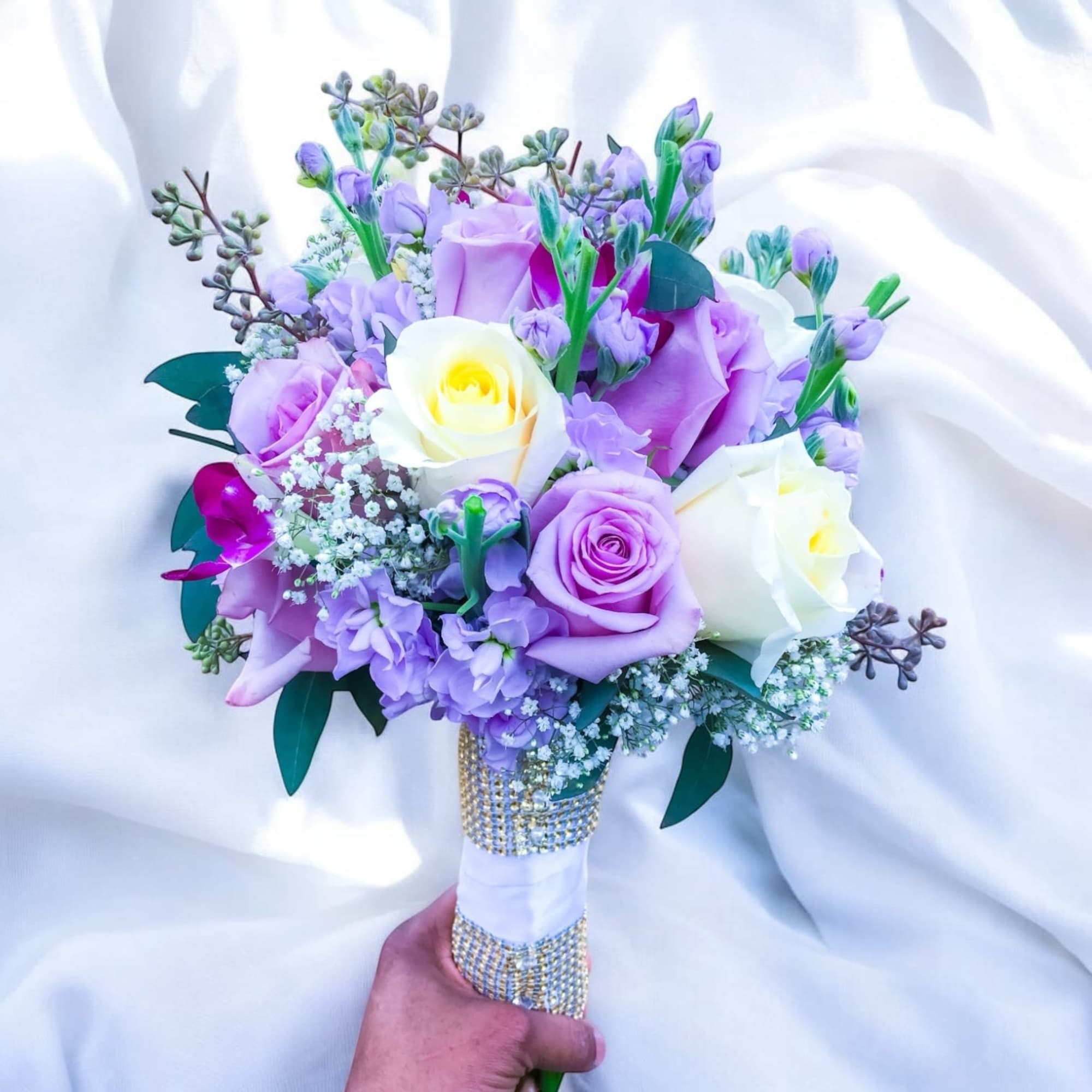 Lavender and white rose bouquet with small filler flowers and a jeweled handle