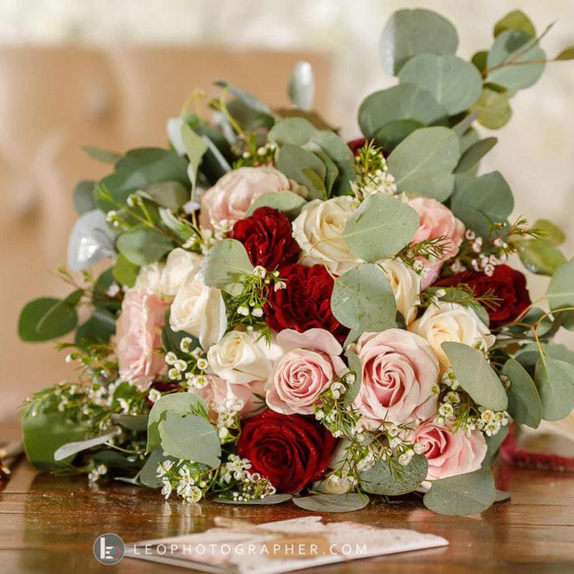 Bouquet of red, blush, and white roses with eucalyptus