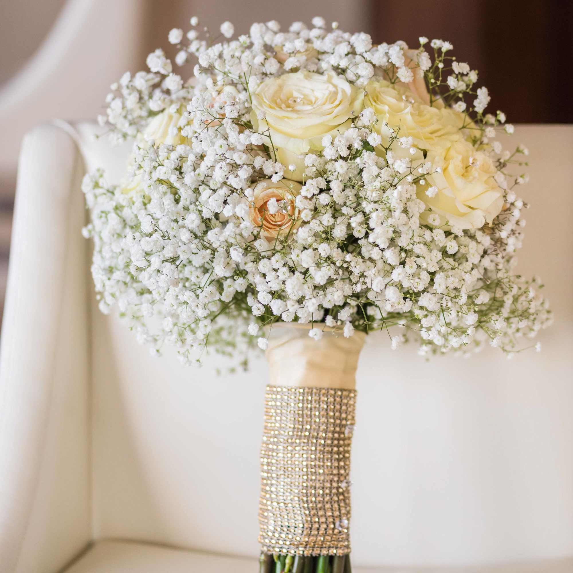 White rose bouquet with baby's breath and a jeweled handle wrap