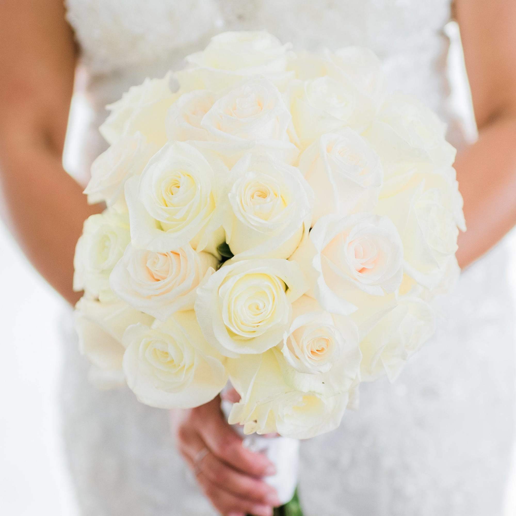 Bride holding a bouquet of white roses
