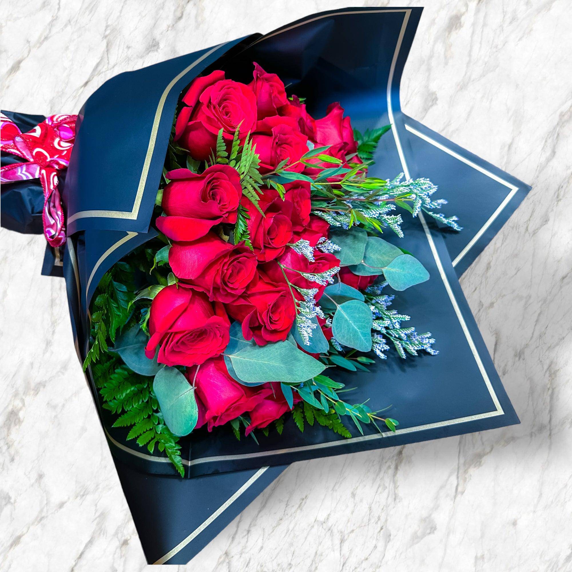 Bouquet of red roses wrapped in dark blue paper