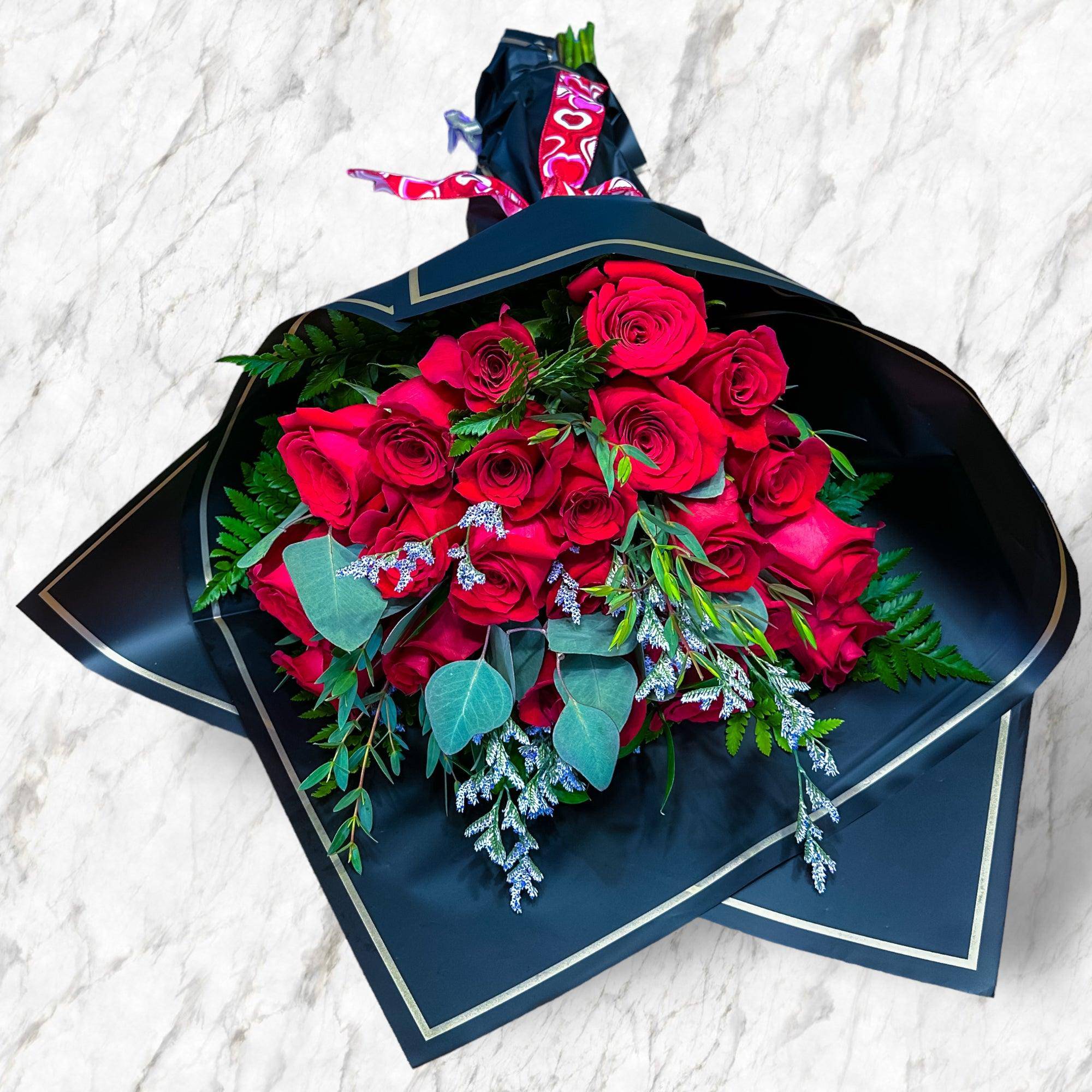 Bouquet of red roses wrapped in black paper