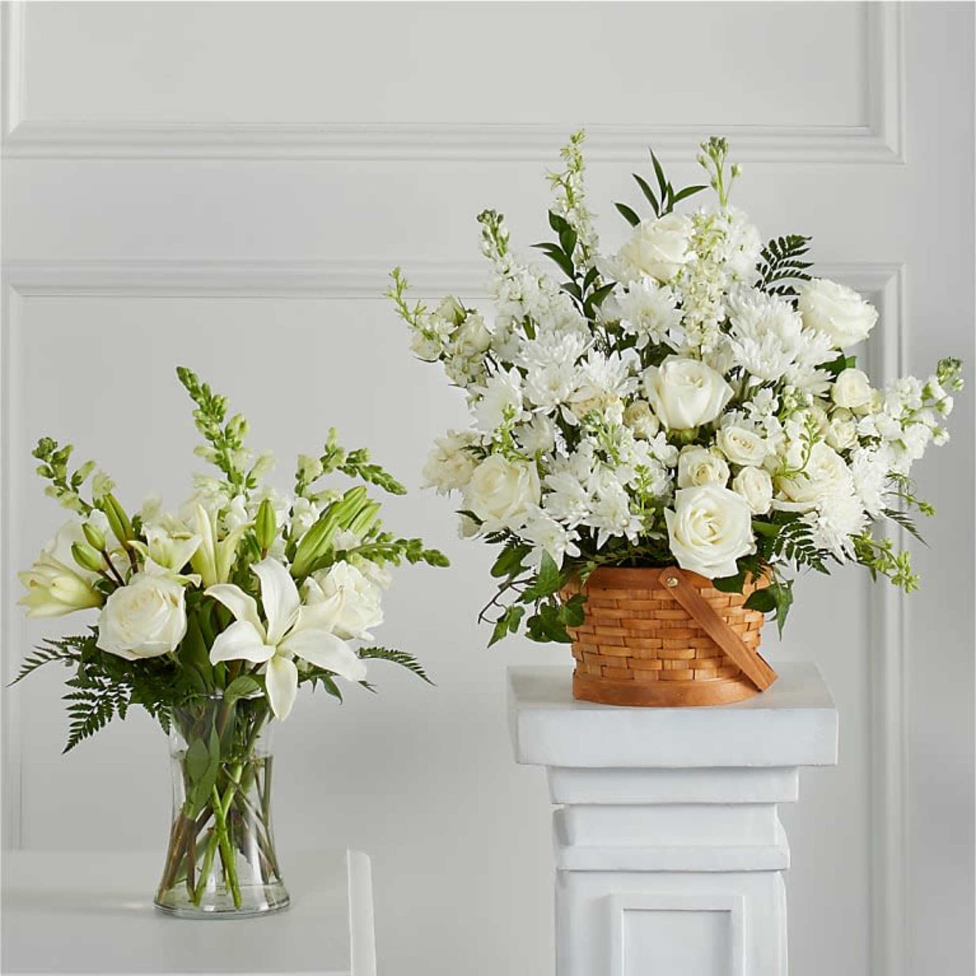 White floral arrangements in a glass vase and wicker basket