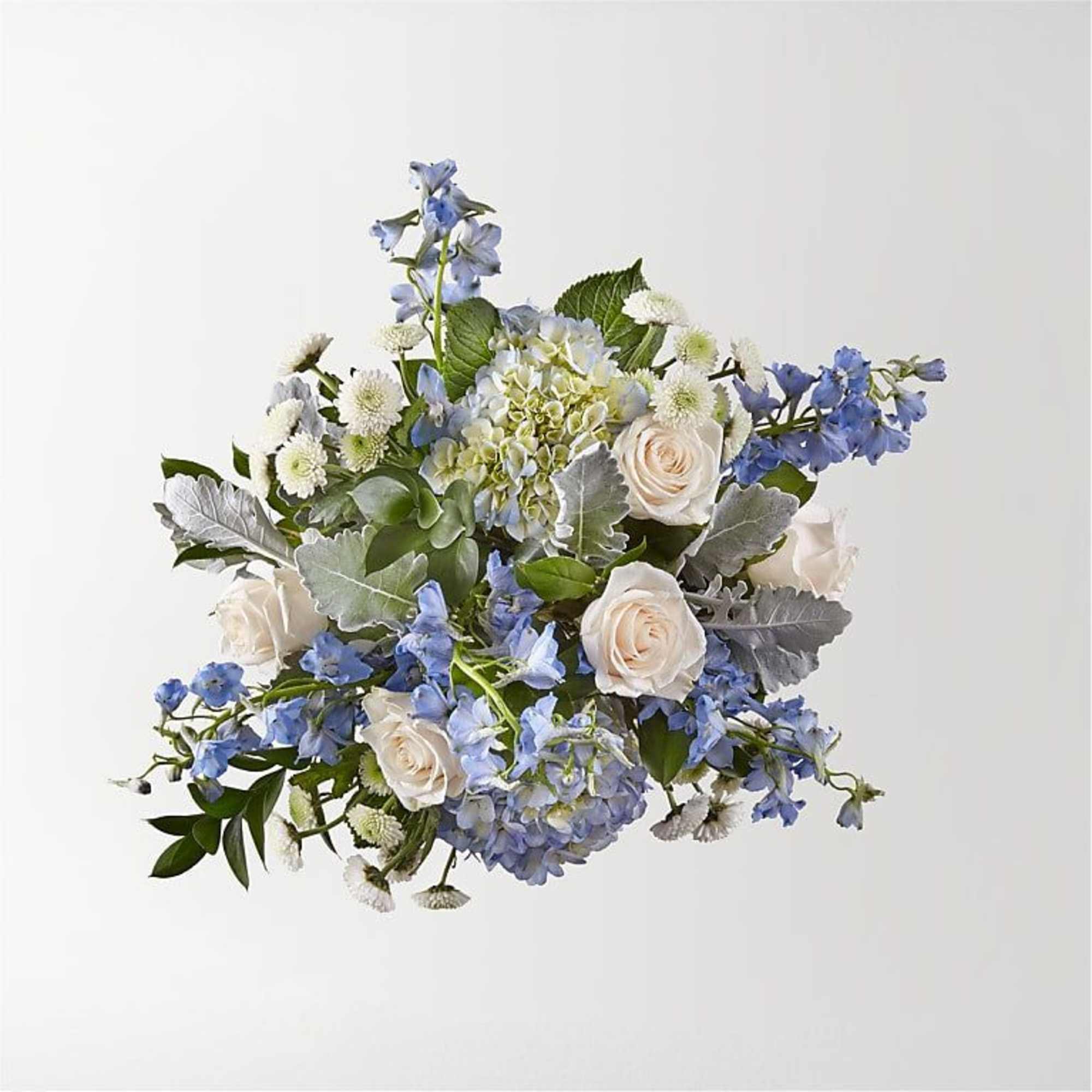 Bouquet of pale roses, blue flowers, and white blooms