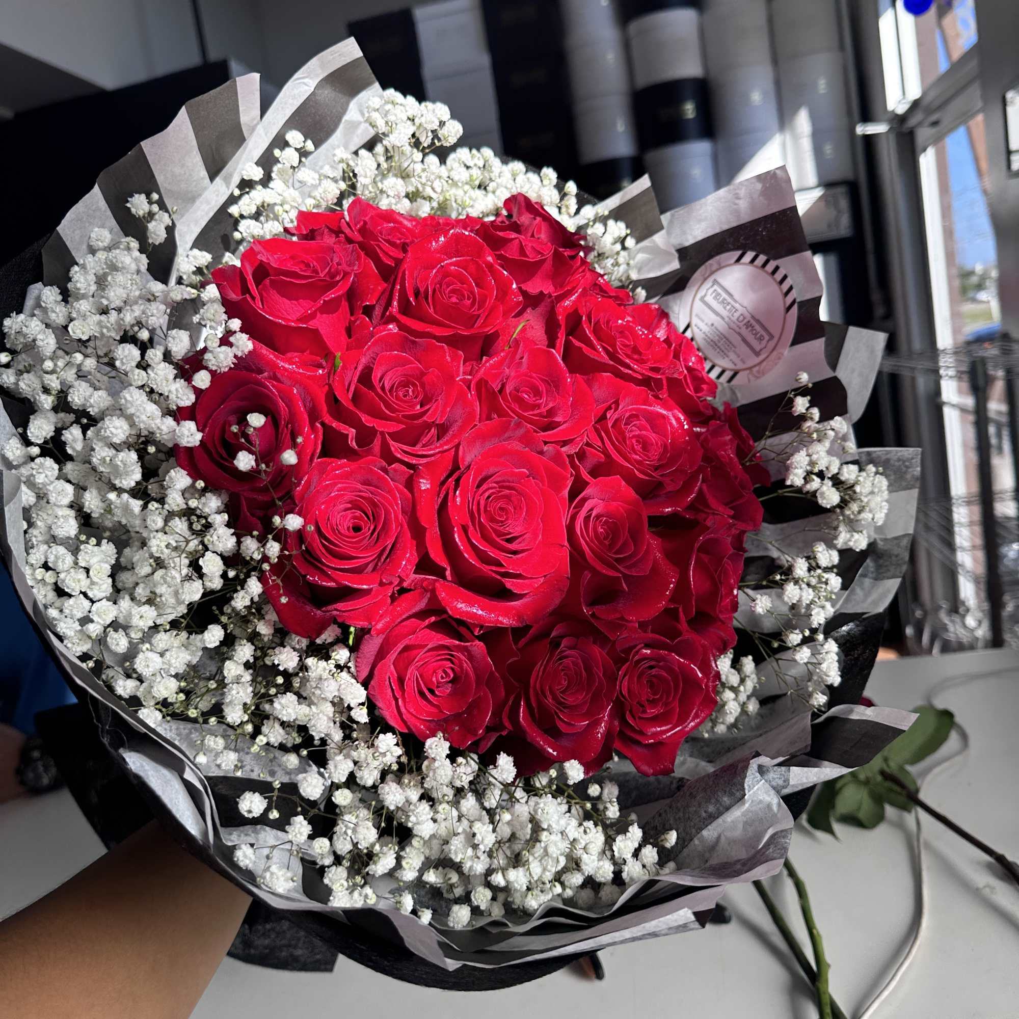 Bouquet of red roses with white baby's breath in black-and-white wrap