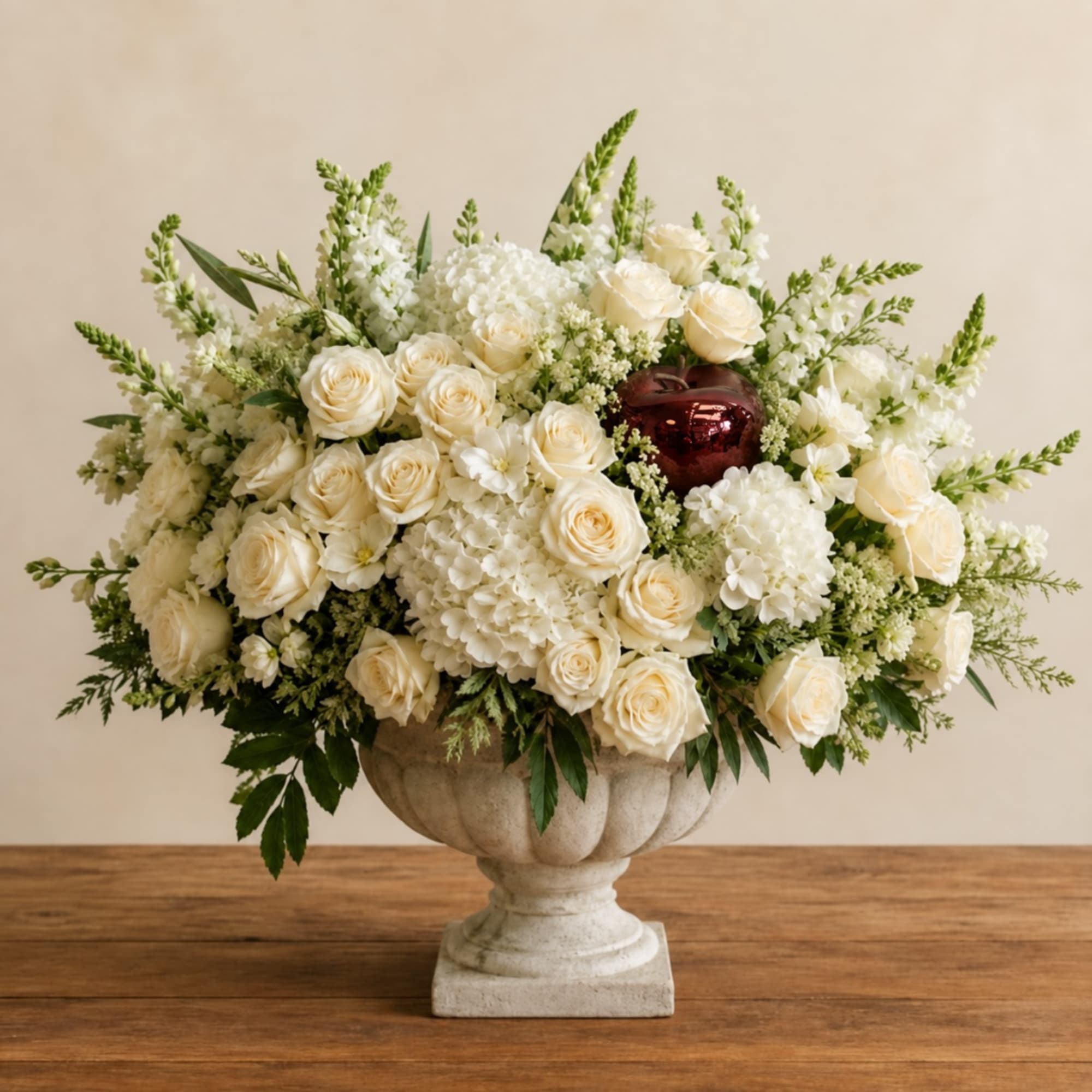 Cream roses and white flowers arranged in a stone urn