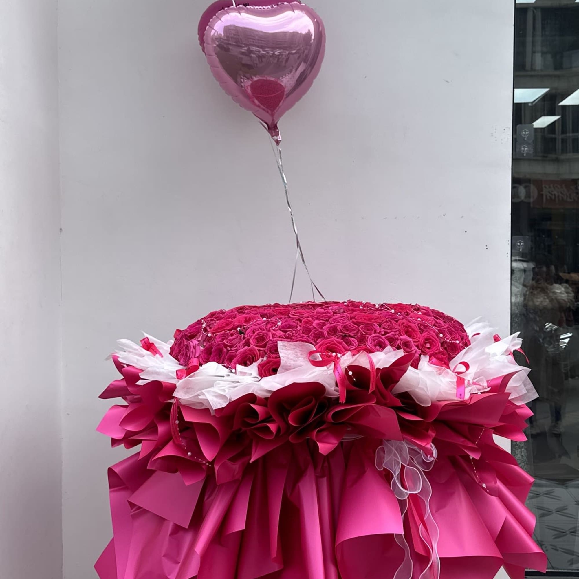 Large pink rose arrangement with two heart balloons