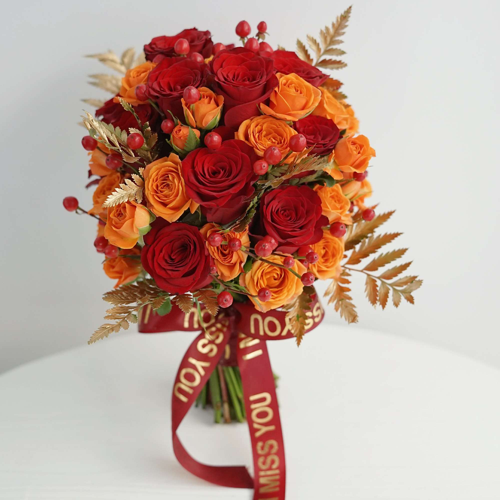 Bouquet of red and orange roses with a red ribbon