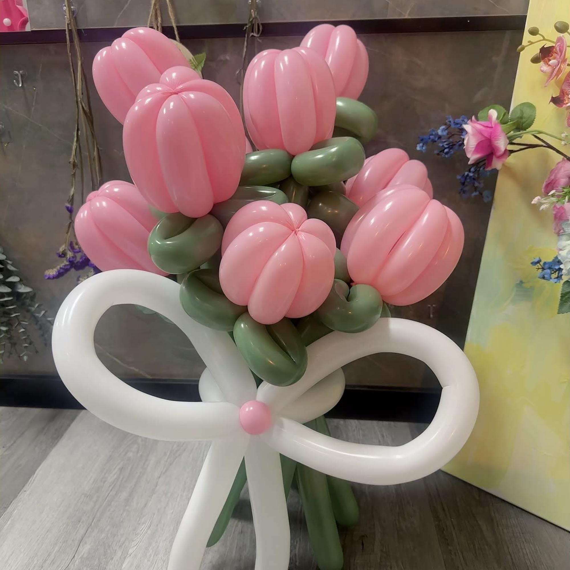 Pink balloon bouquet tied with a large white bow
