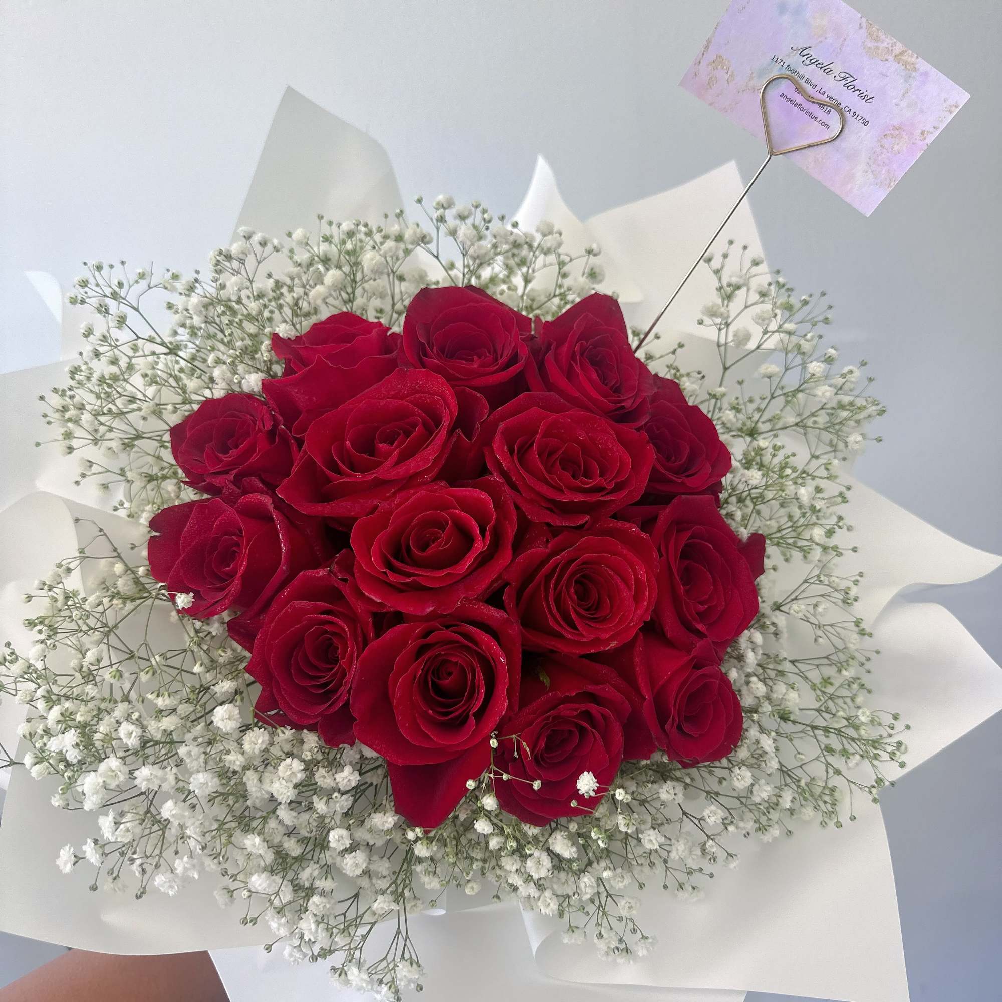 Bouquet of red roses with white baby's breath in white wrapping
