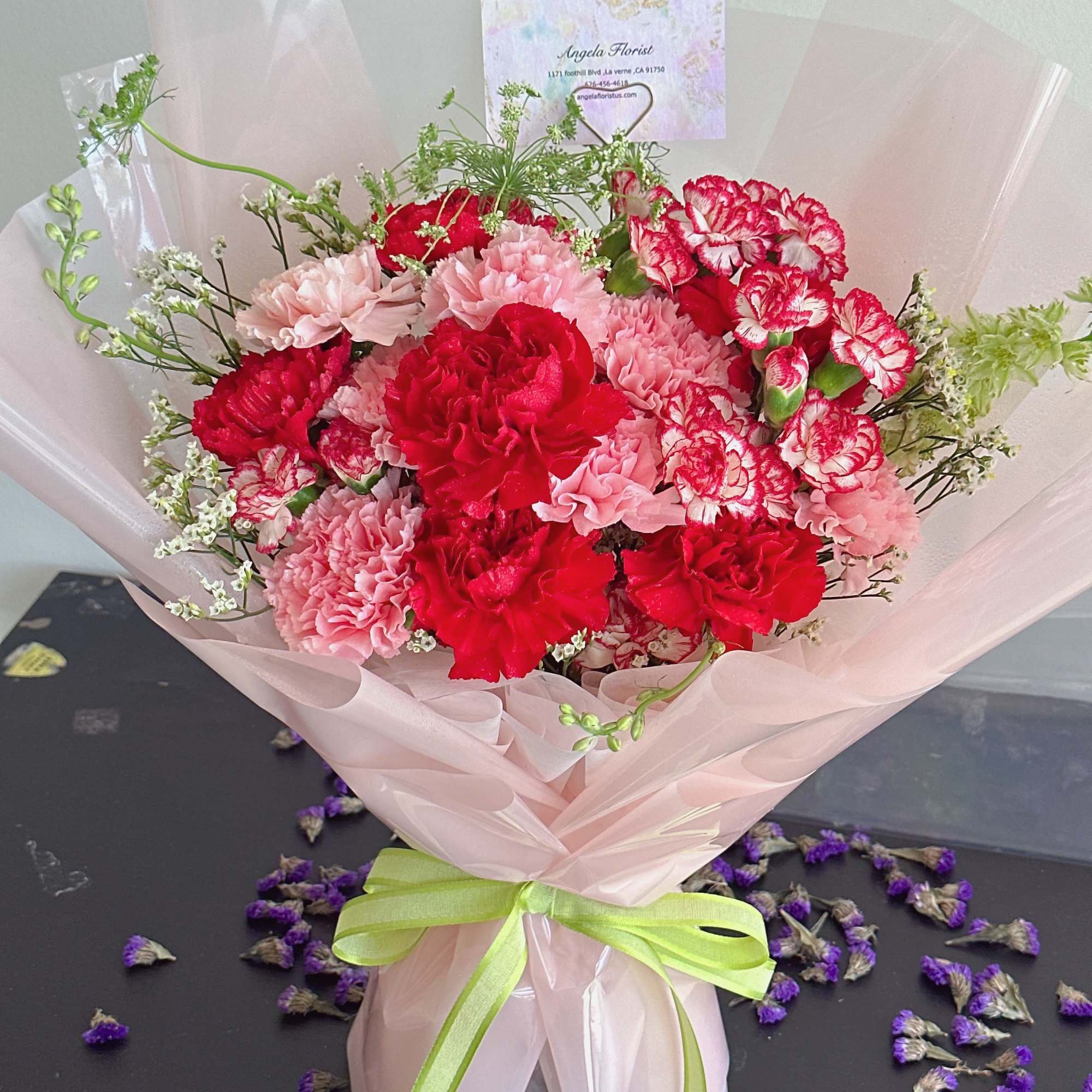 The product contains red and pink carnations with green leafy flowers and, photo 2 of 3