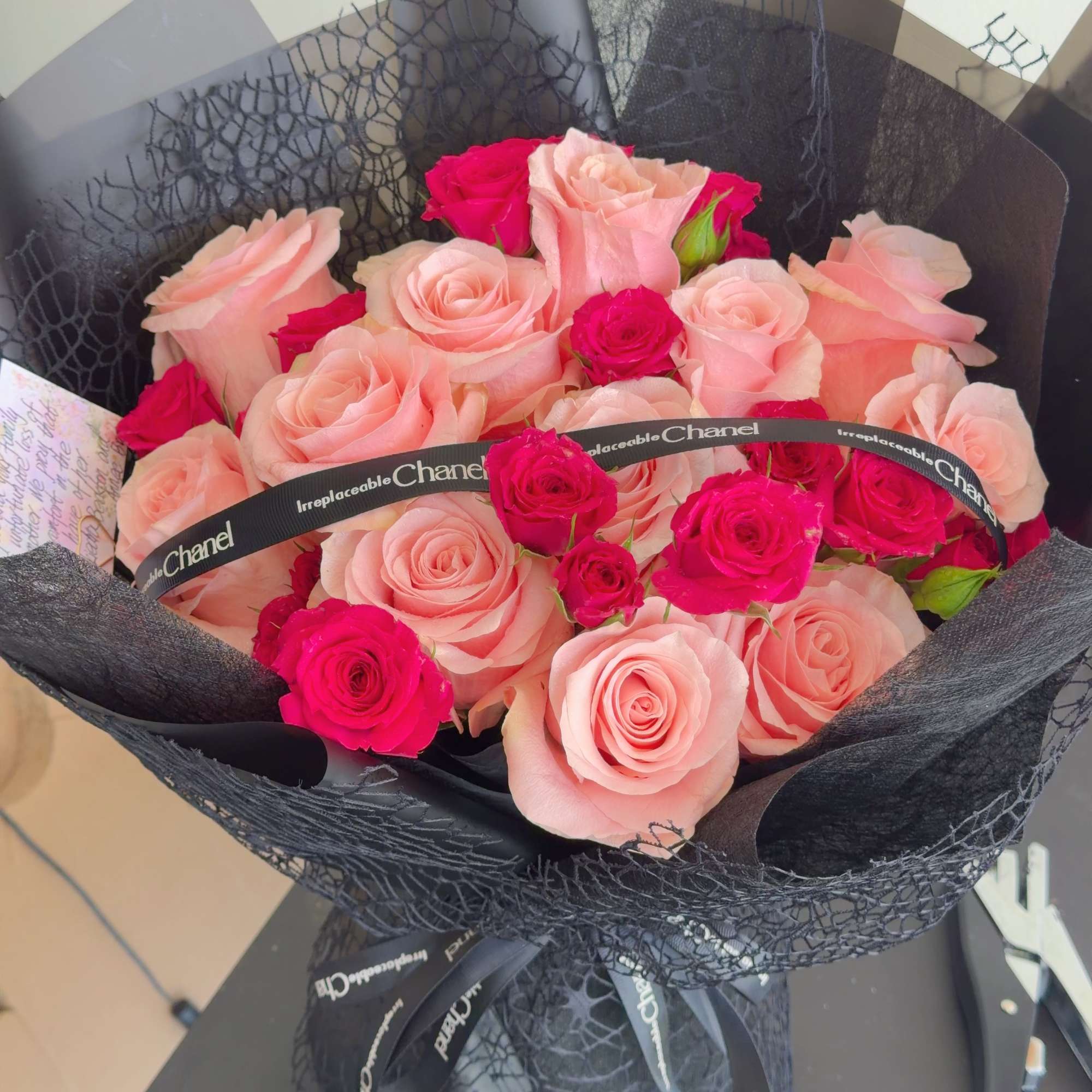 Bouquet of pale pink and hot pink roses wrapped in black paper, photo 3 of 4