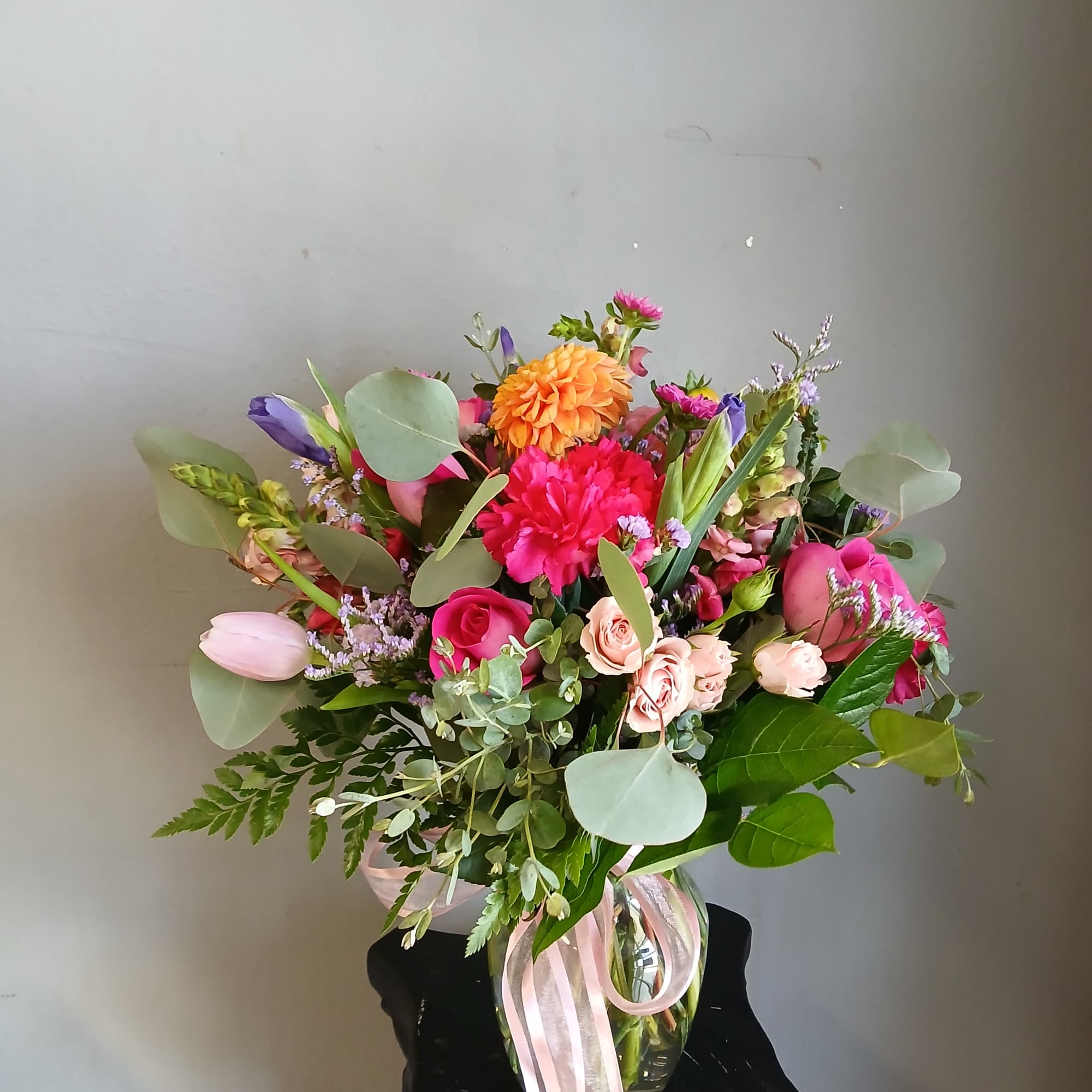 Mixed bouquet in a glass vase with pink, orange, and purple flowers