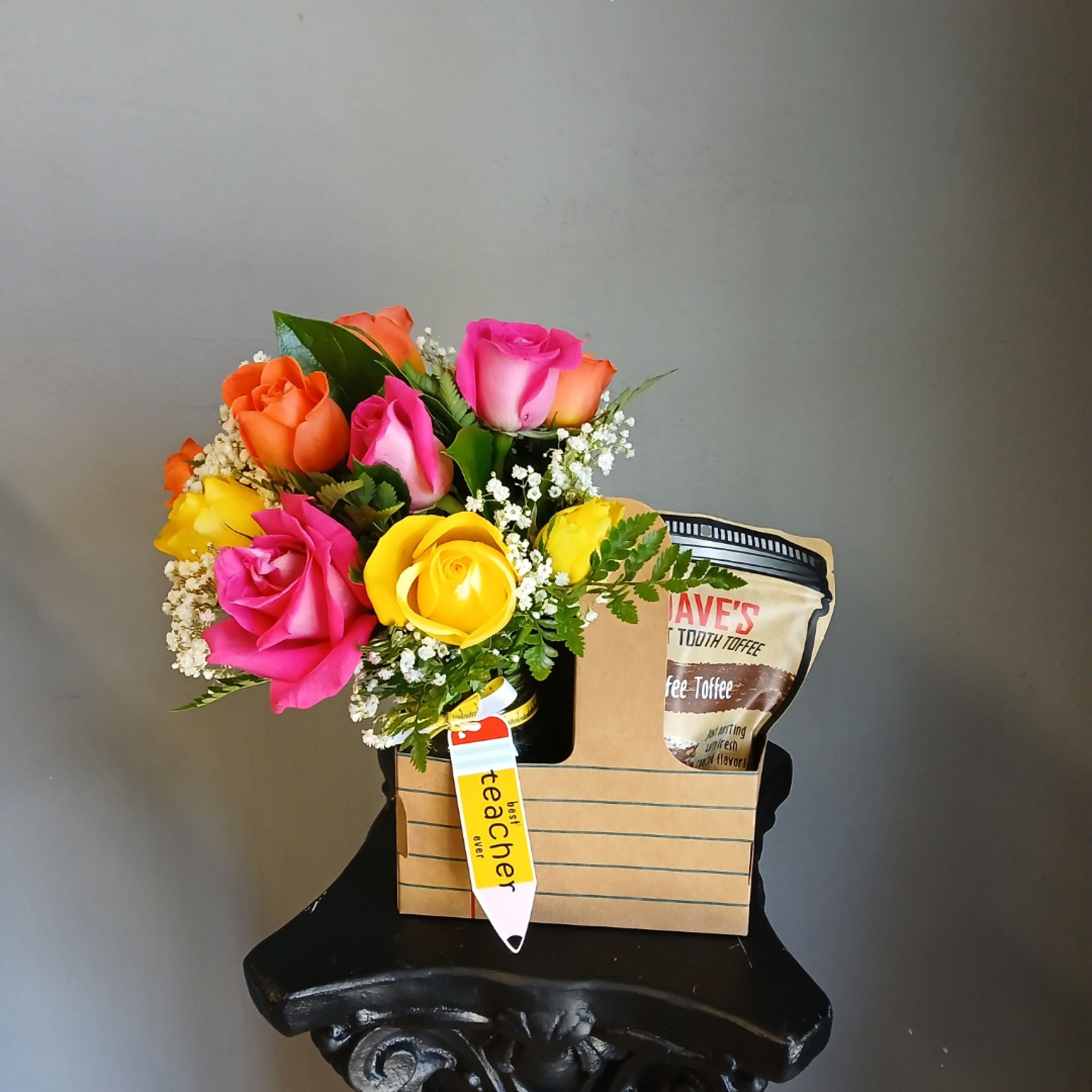 Colorful roses in a paper gift bag with a toffee package and teacher tag