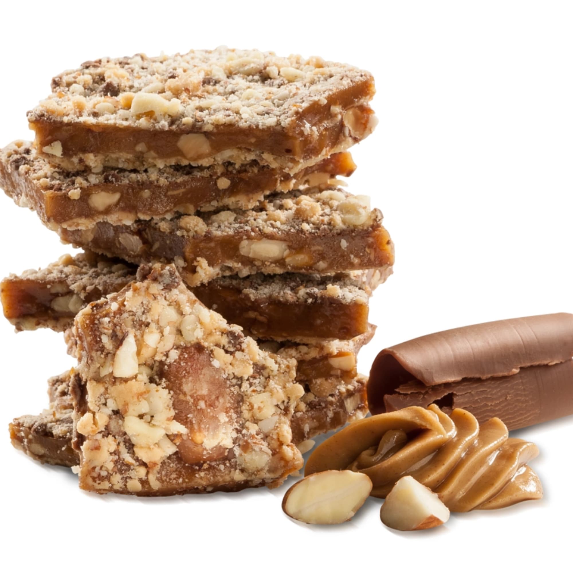 Stacked nut brittle pieces with a chocolate curl and caramel drizzle