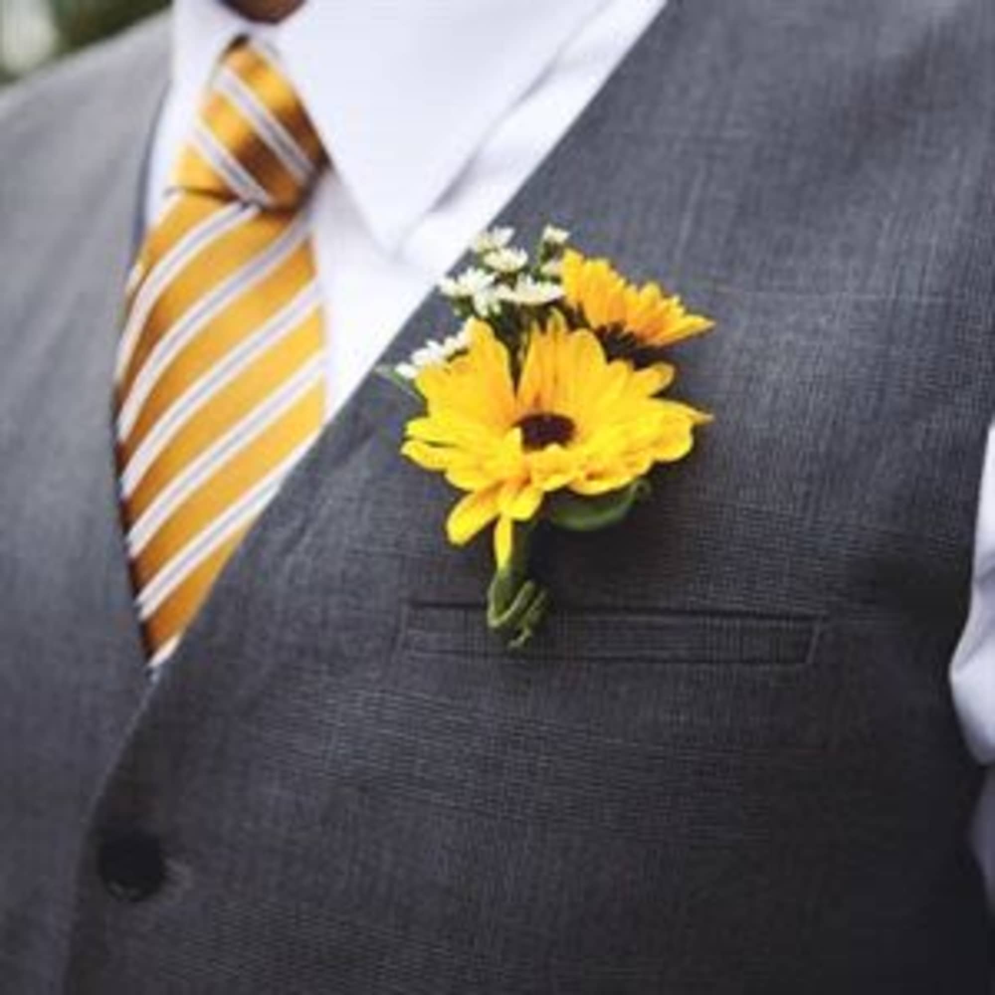 Yellow flower boutonniere pinned to a gray suit jacket