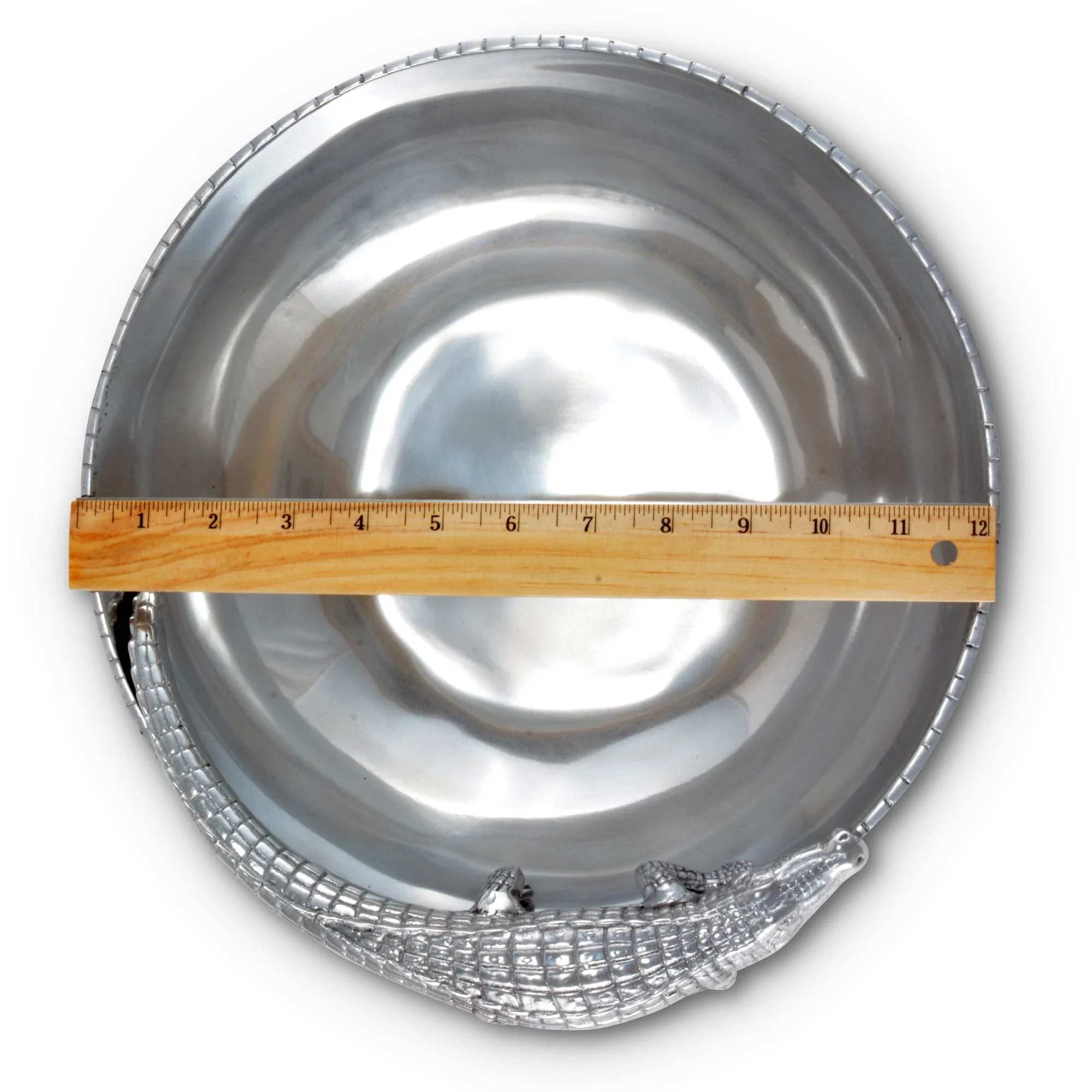 Silver metal bowl with a ruler laid across it