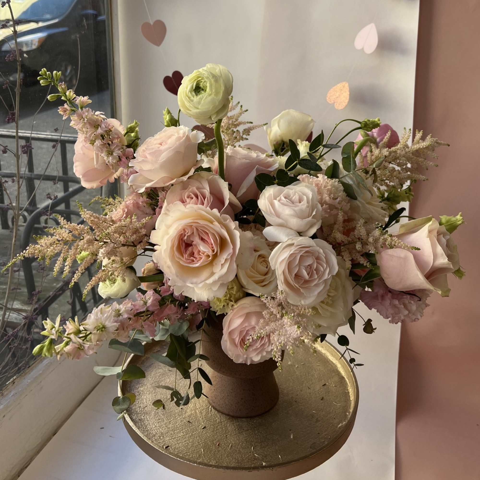 Blush and white rose bouquet in a brown vase