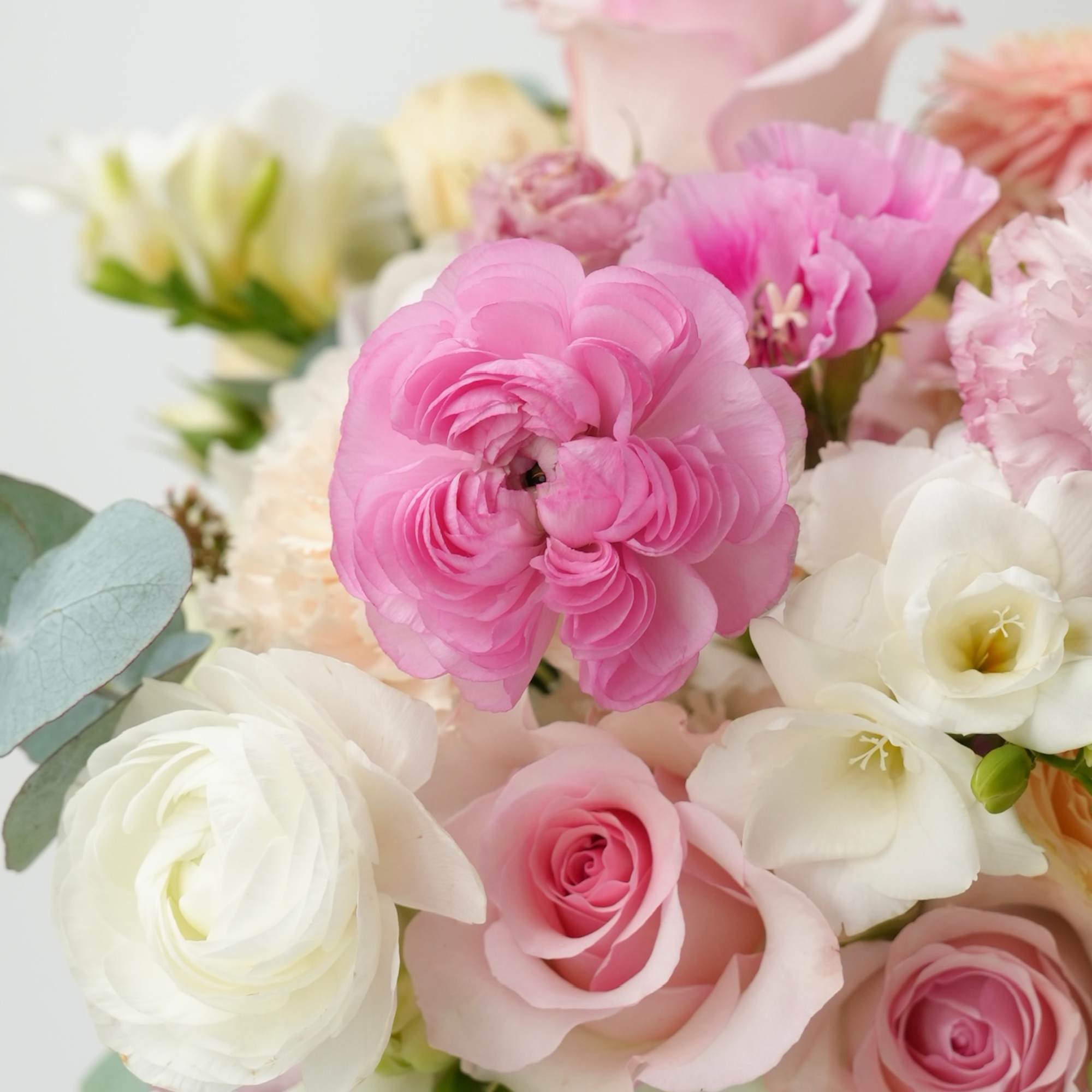 Pink and white bouquet with roses and ranunculus in a vase