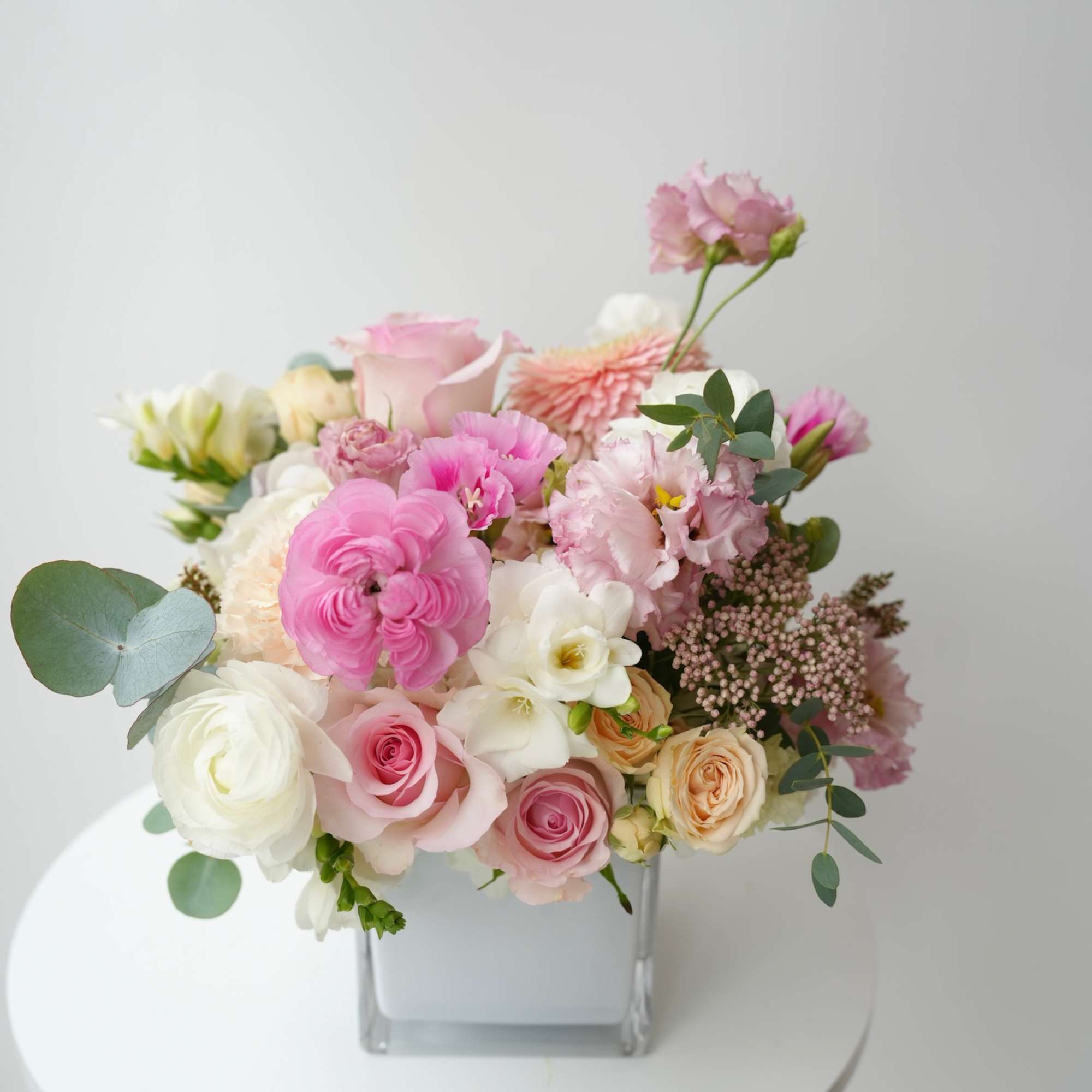 Pink and white mixed bouquet in a square glass vase