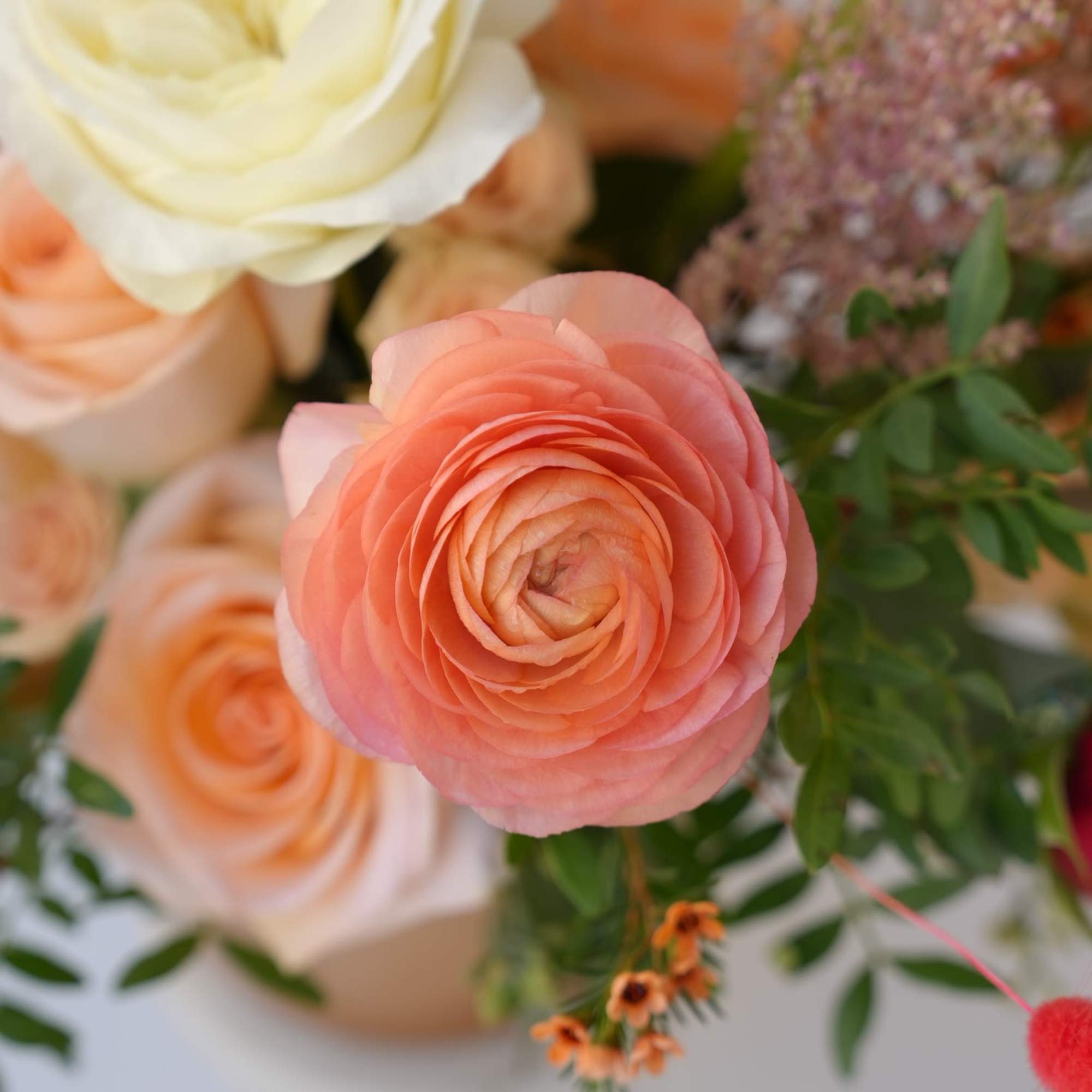 Close-up bouquet with peach and cream roses and greenery