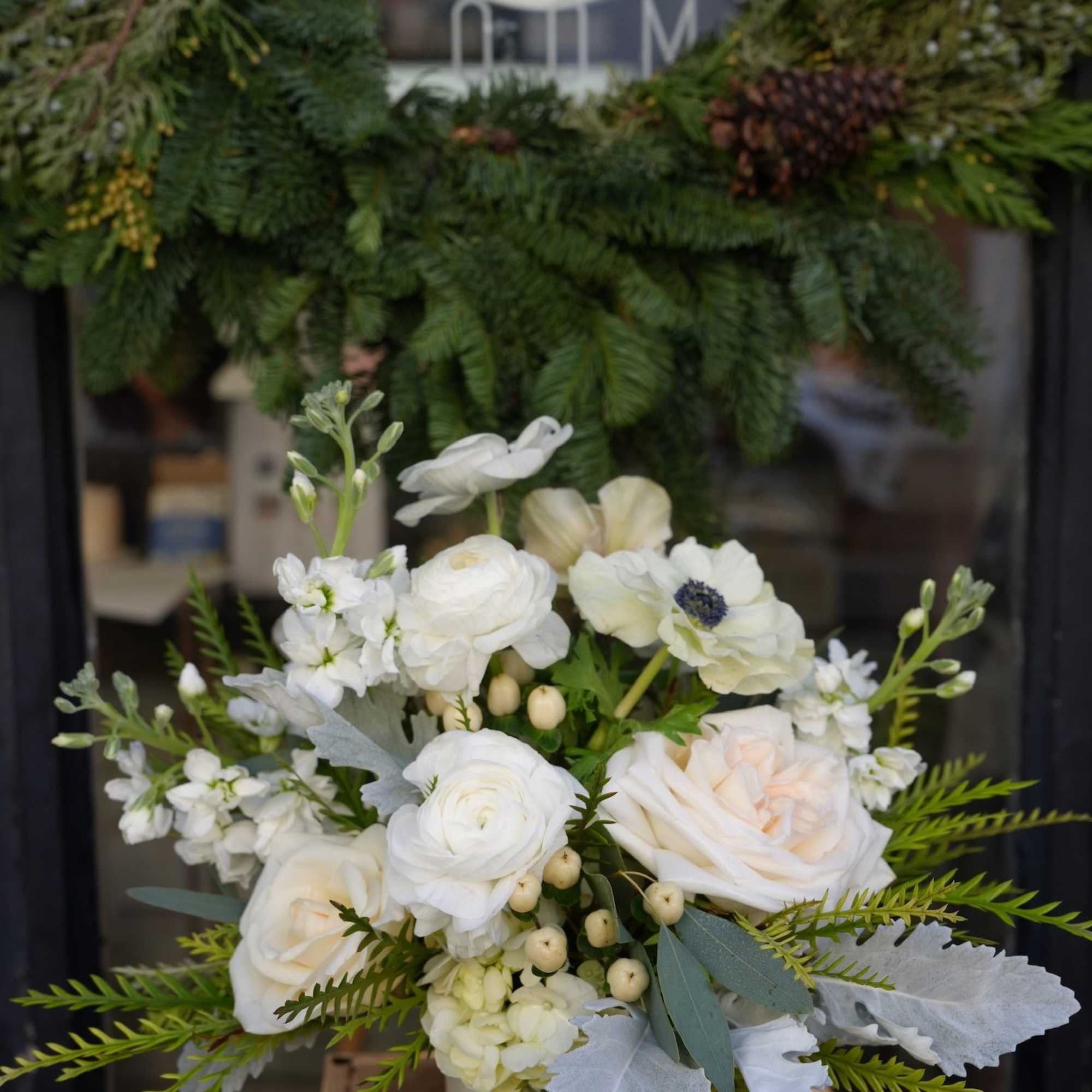 White floral bouquet with roses and ranunculus in a vase