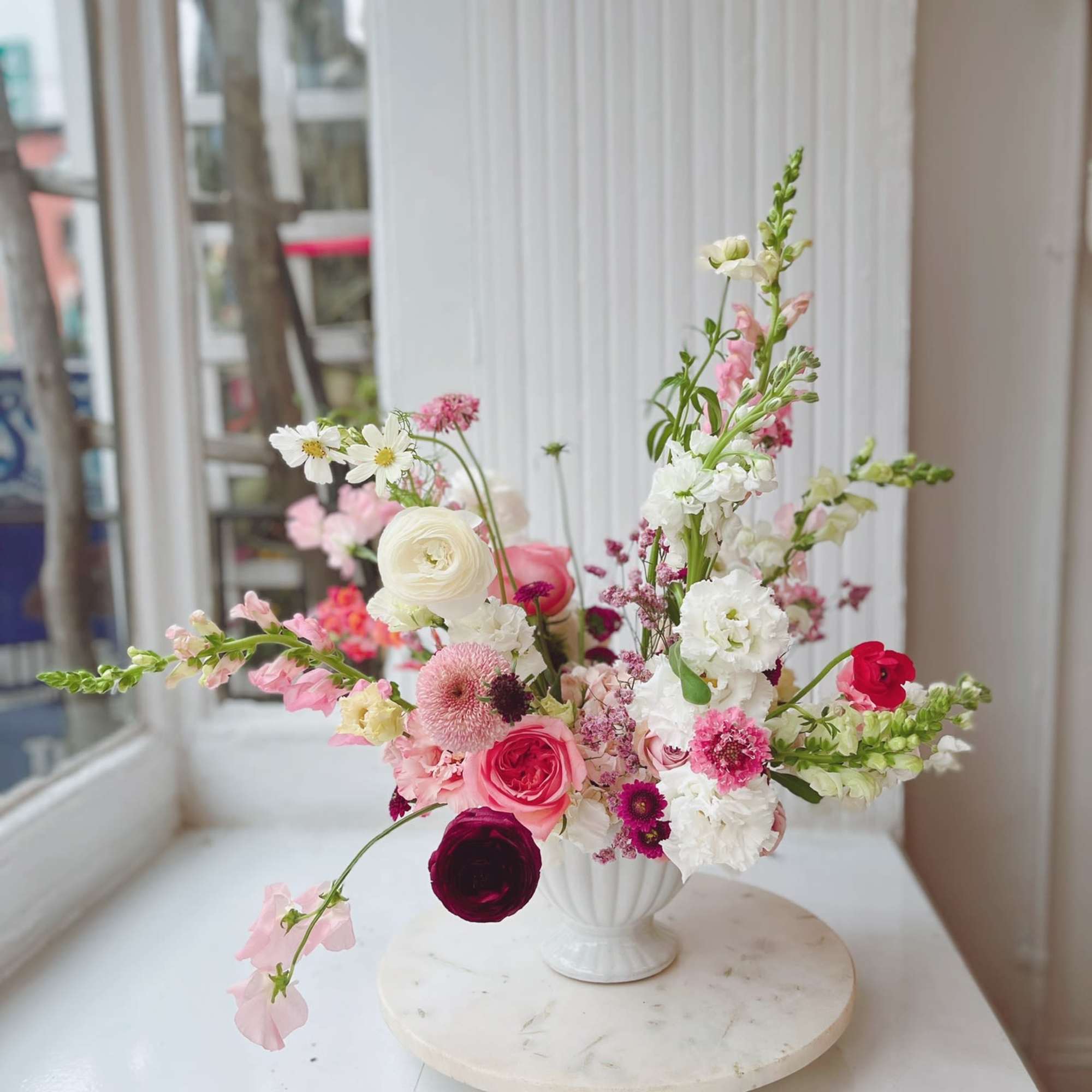 Pink and white mixed flower arrangement in a white vase