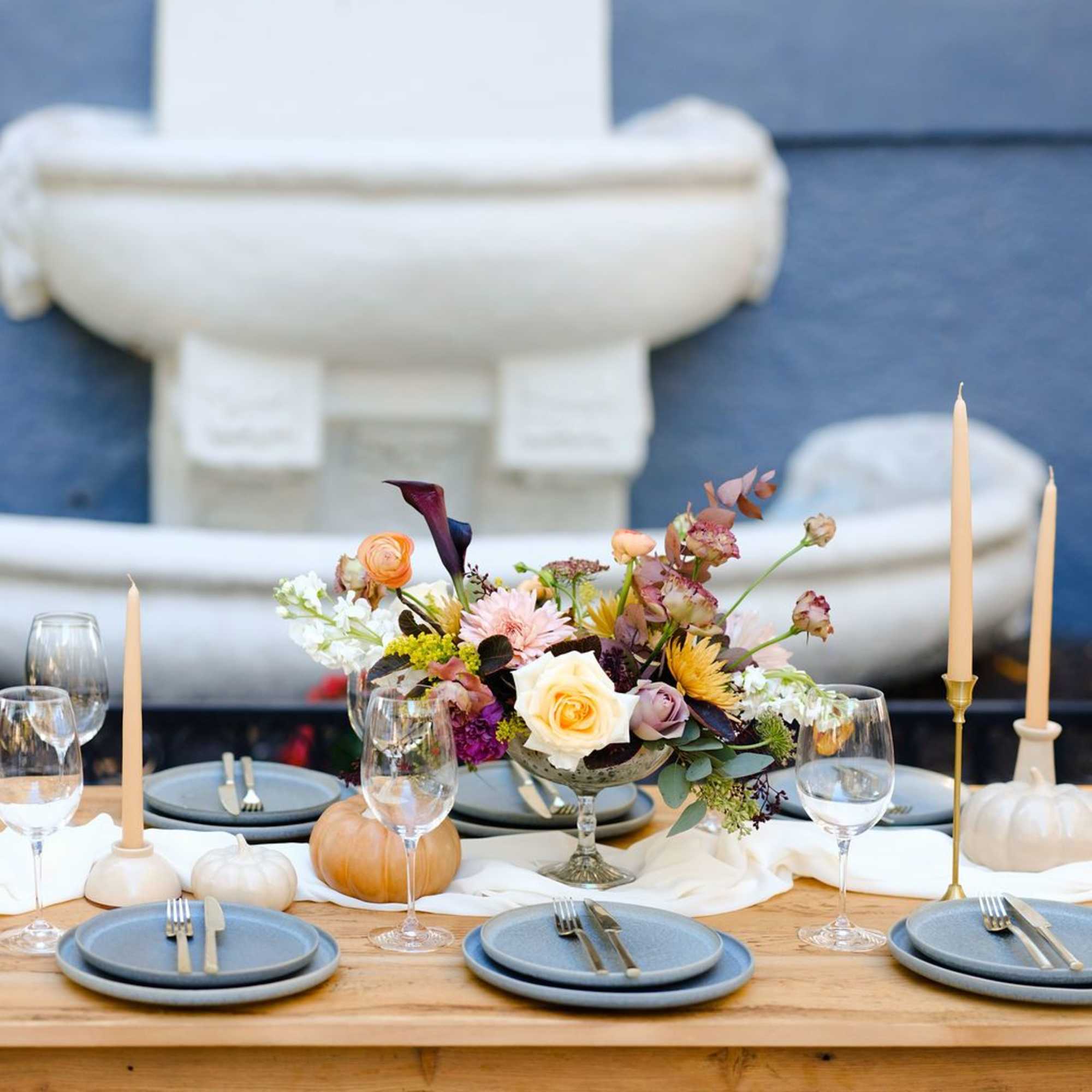Low floral centerpiece with roses and mixed blooms on a dining table