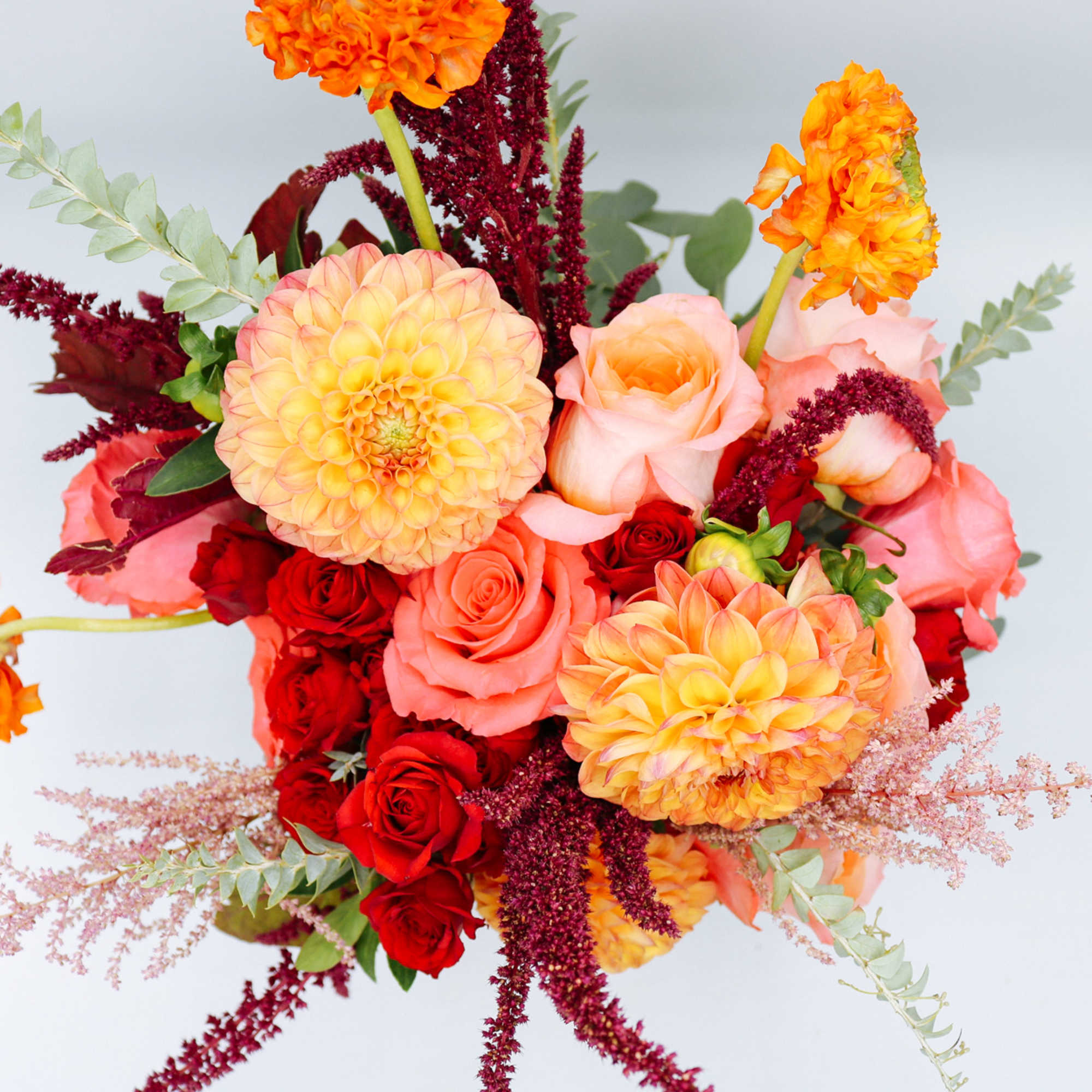 Bouquet of orange dahlias and pink roses with red accents
