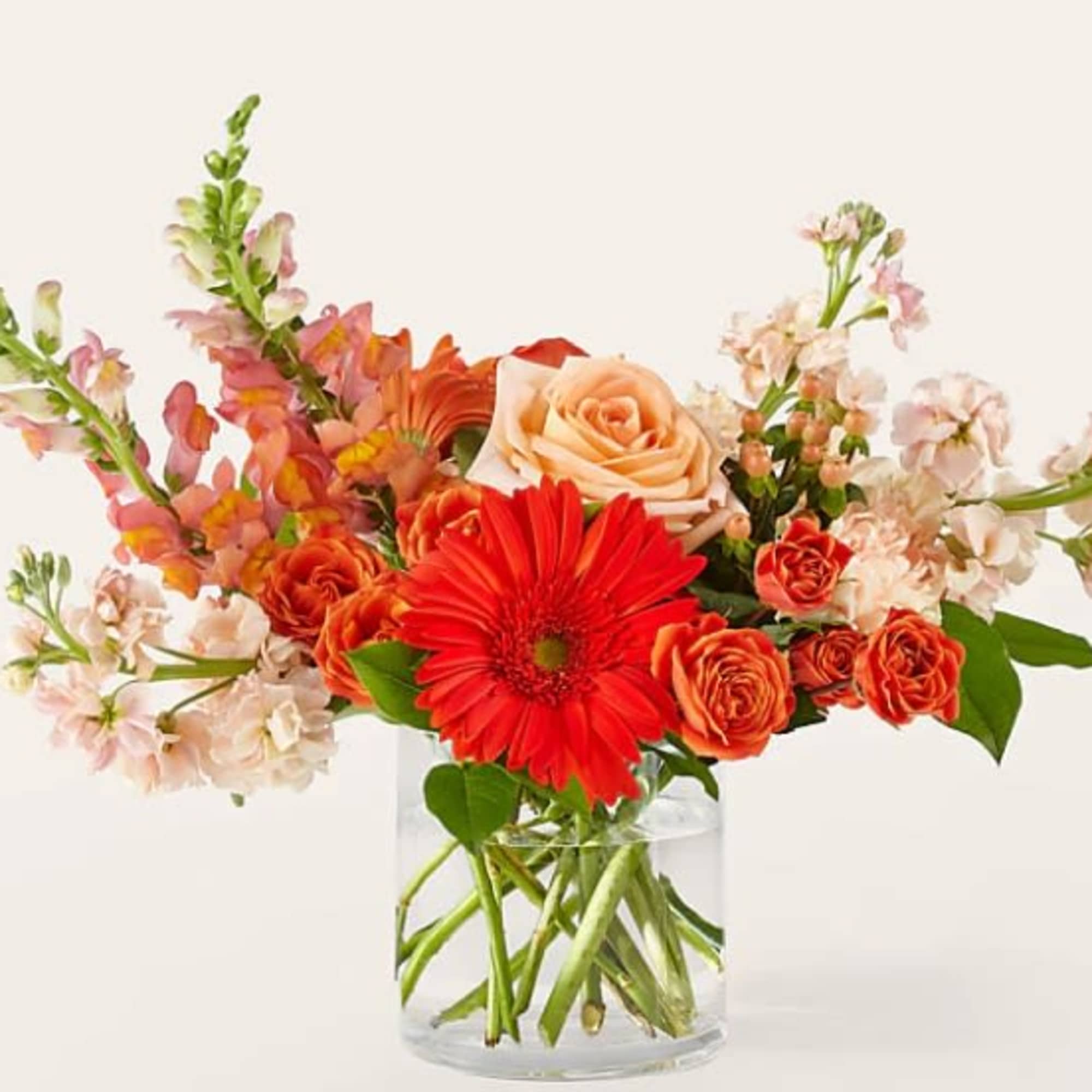 Orange and peach flowers in a clear glass vase