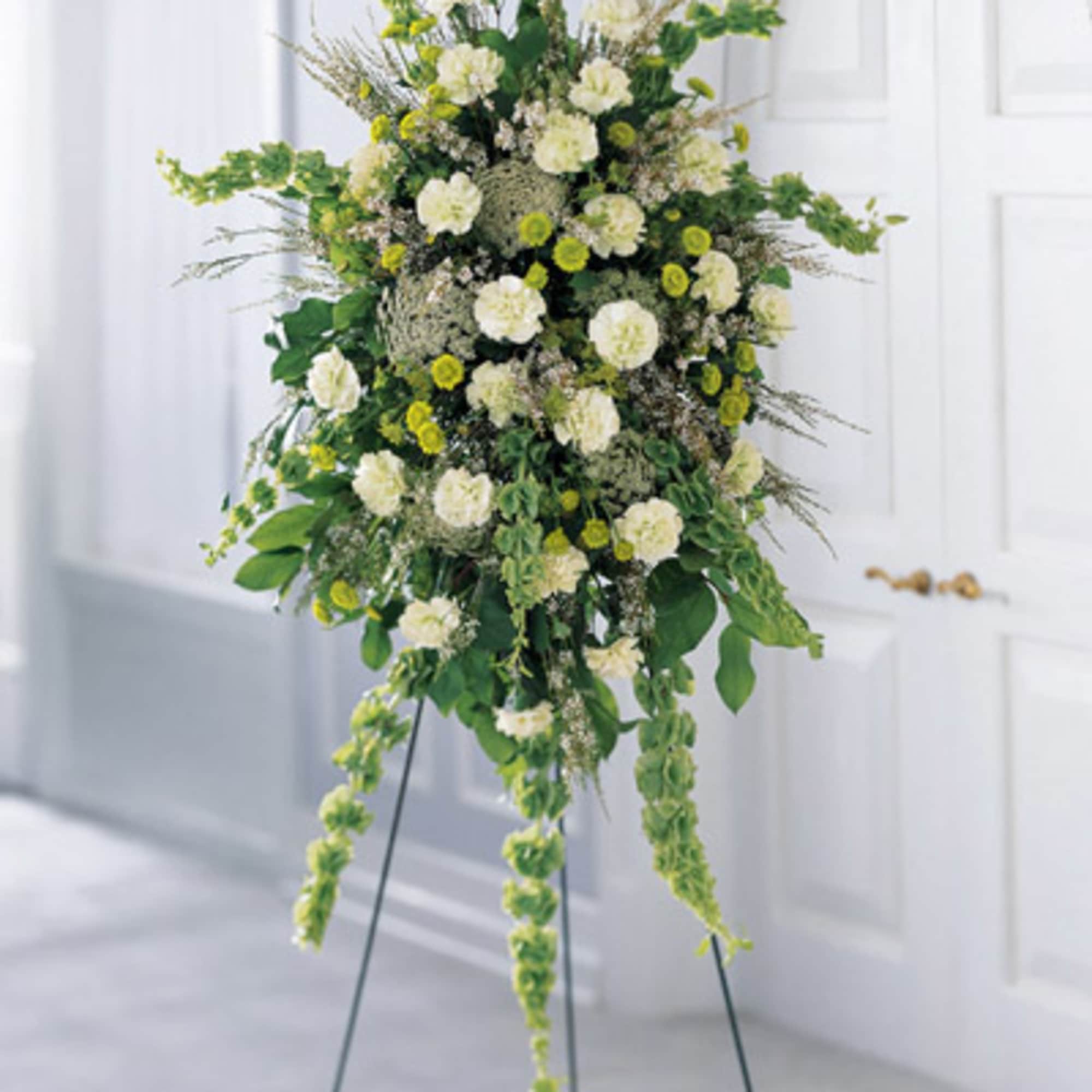 Tall white and green floral standing arrangement on an easel