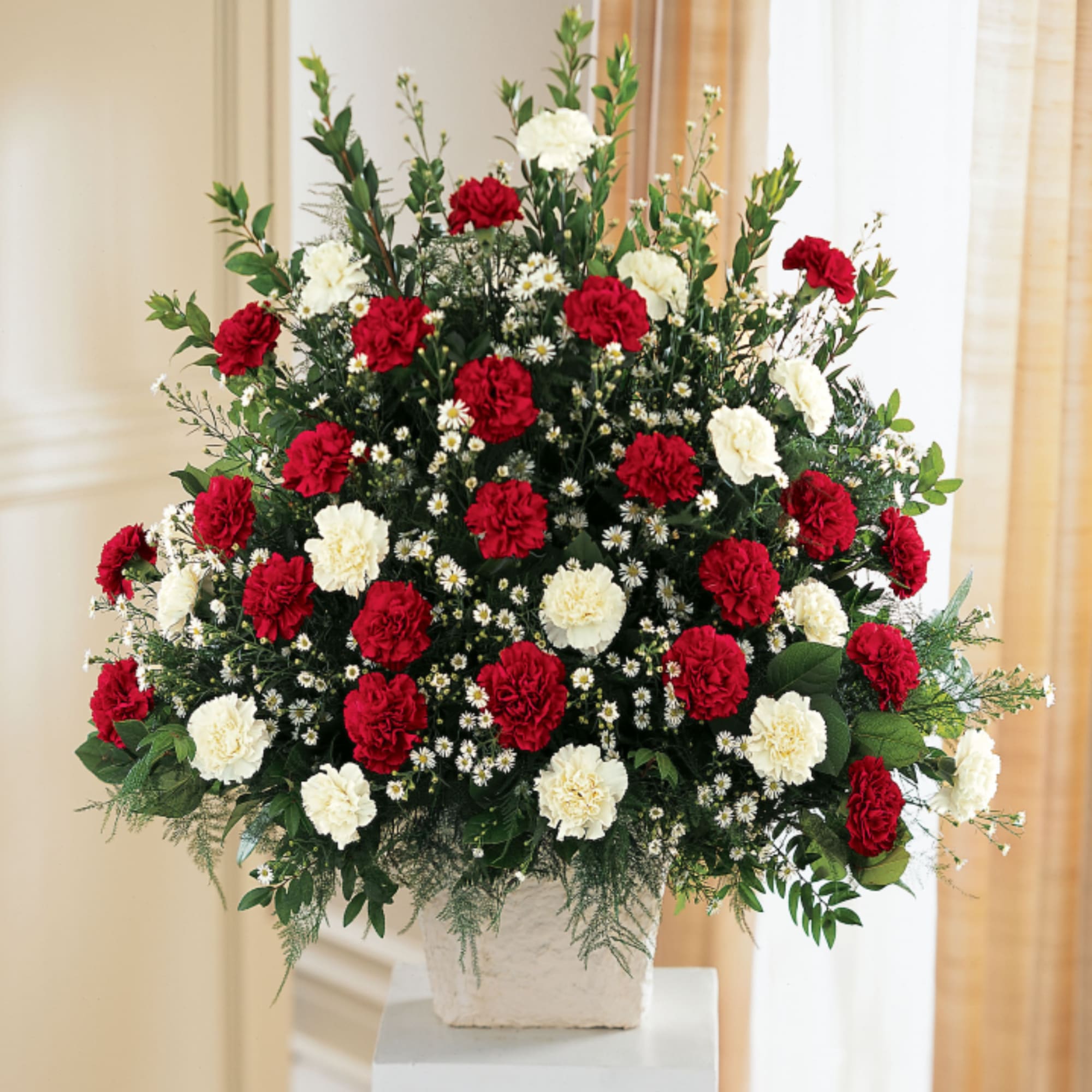 Red carnations and white carnations are accented with white monte casino in