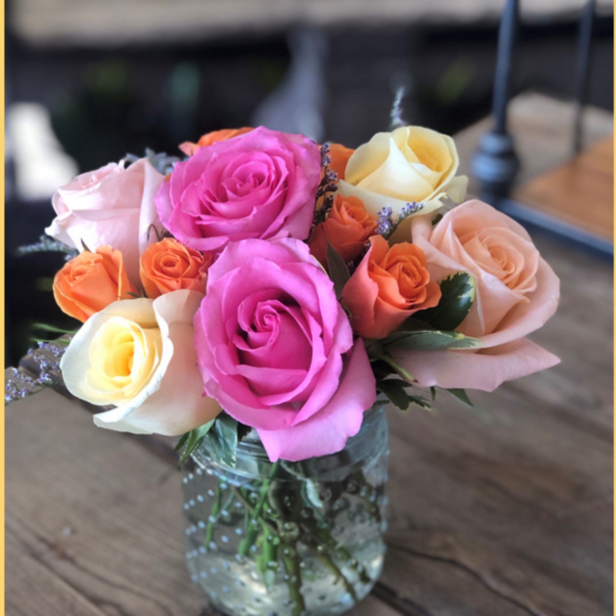 Mixed roses in a clear glass jar vase