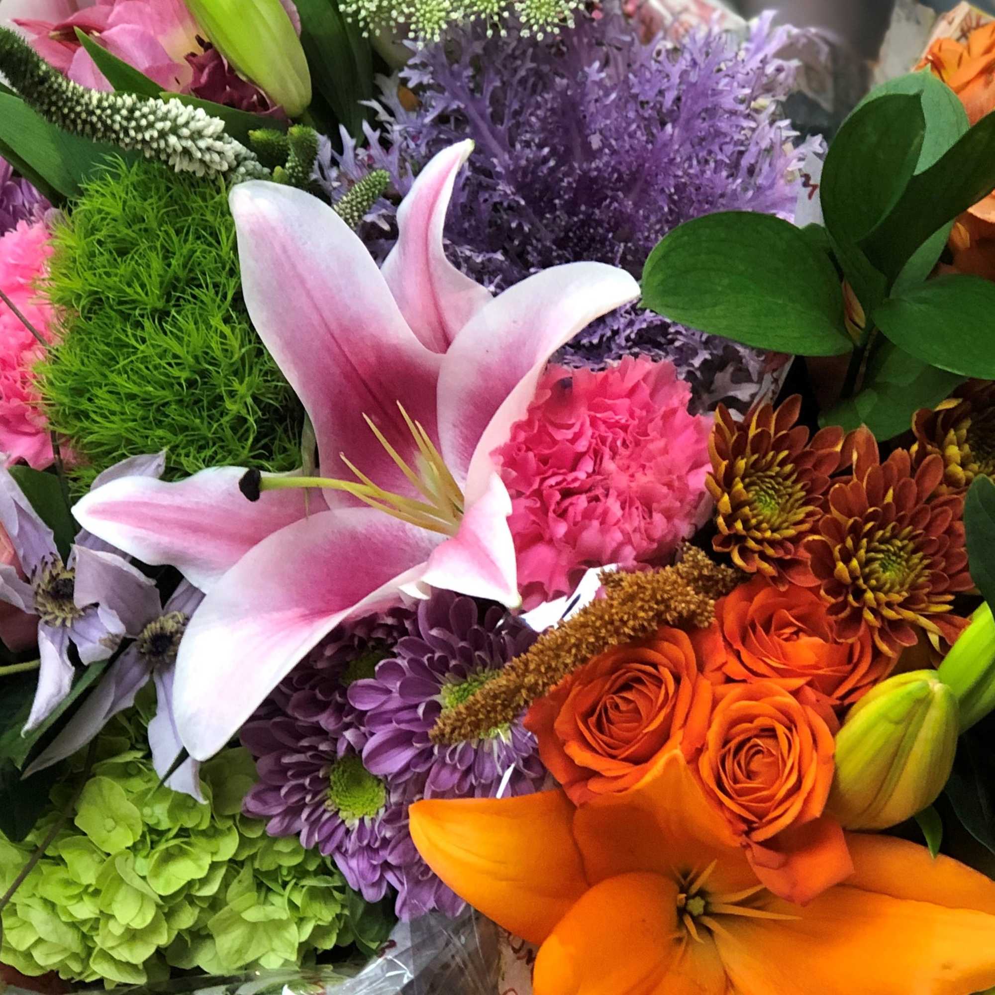 Mixed bouquet with pink lilies, orange roses, and purple flowers