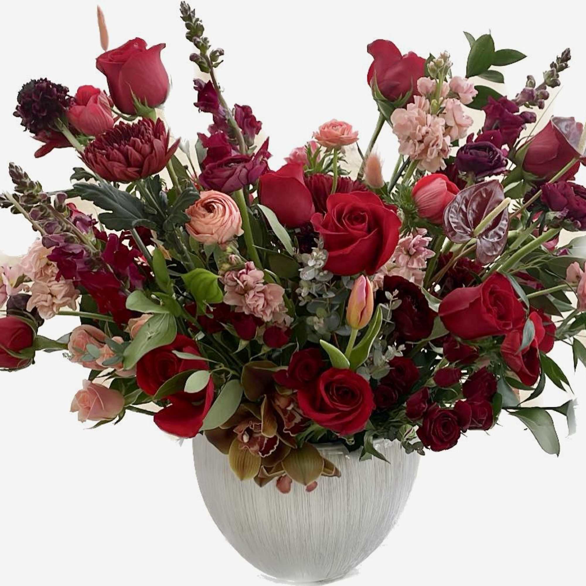 Large bouquet of red and pink flowers in a white vase
