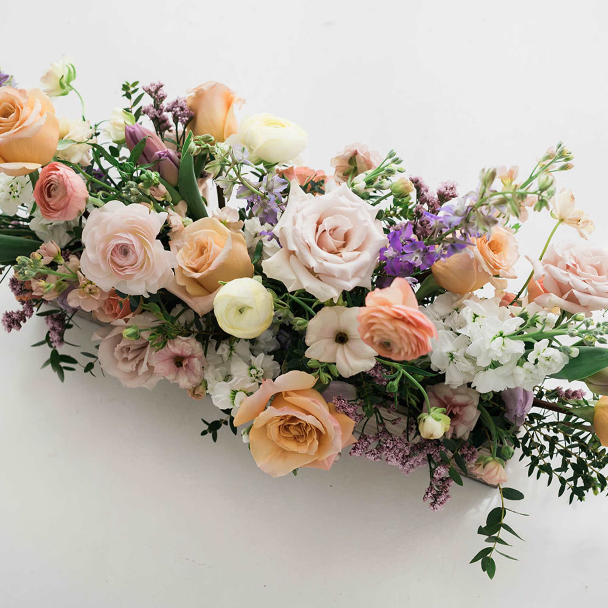 Pastel bouquet of roses, ranunculus, and small white blooms