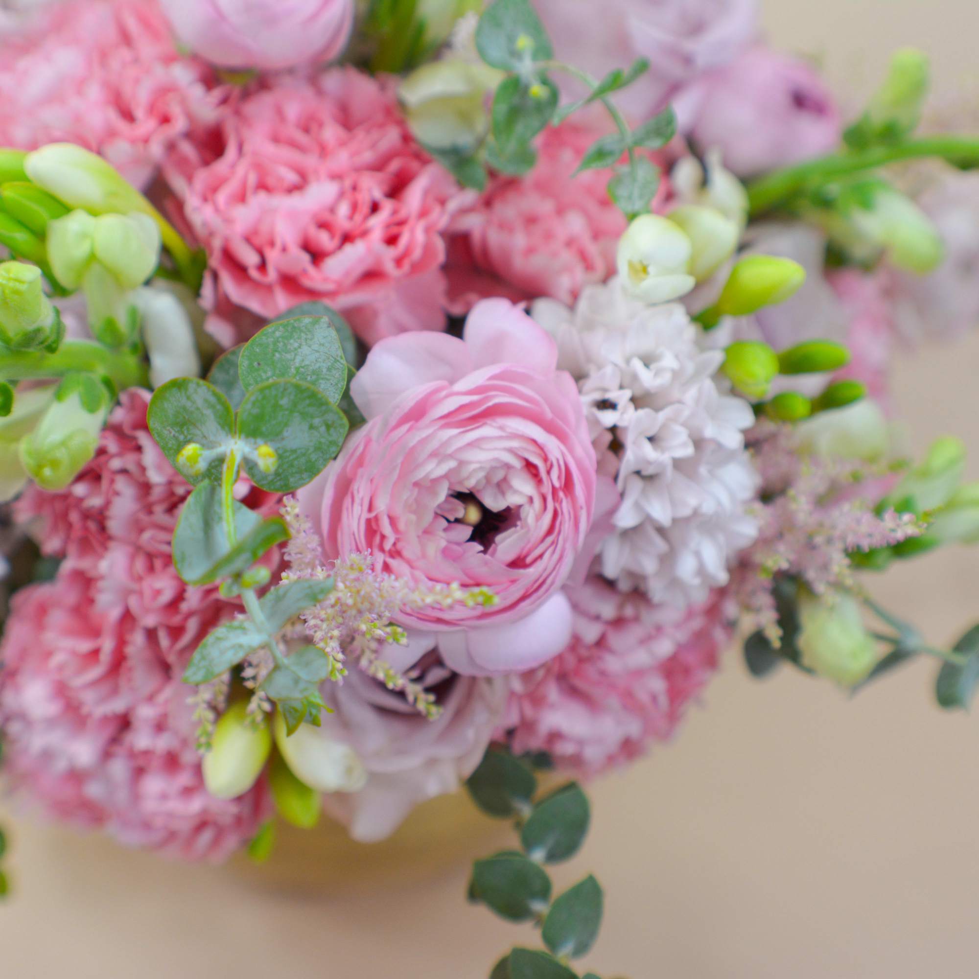 Pink bouquet with ranunculus, carnations, and white blooms