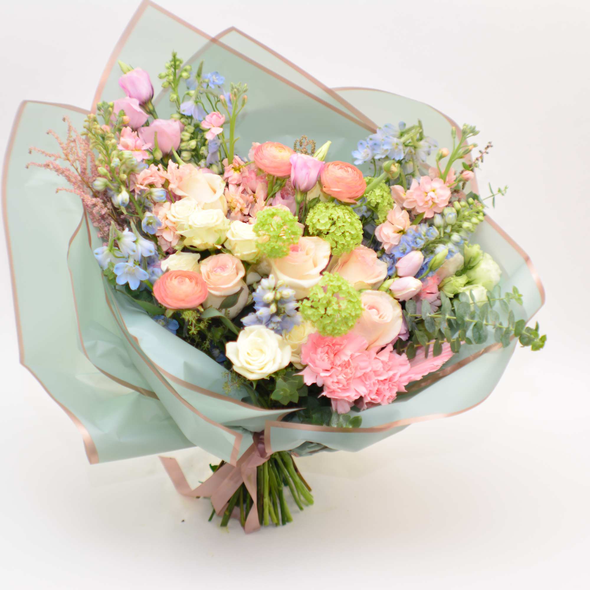 Pastel mixed bouquet wrapped in pale blue paper