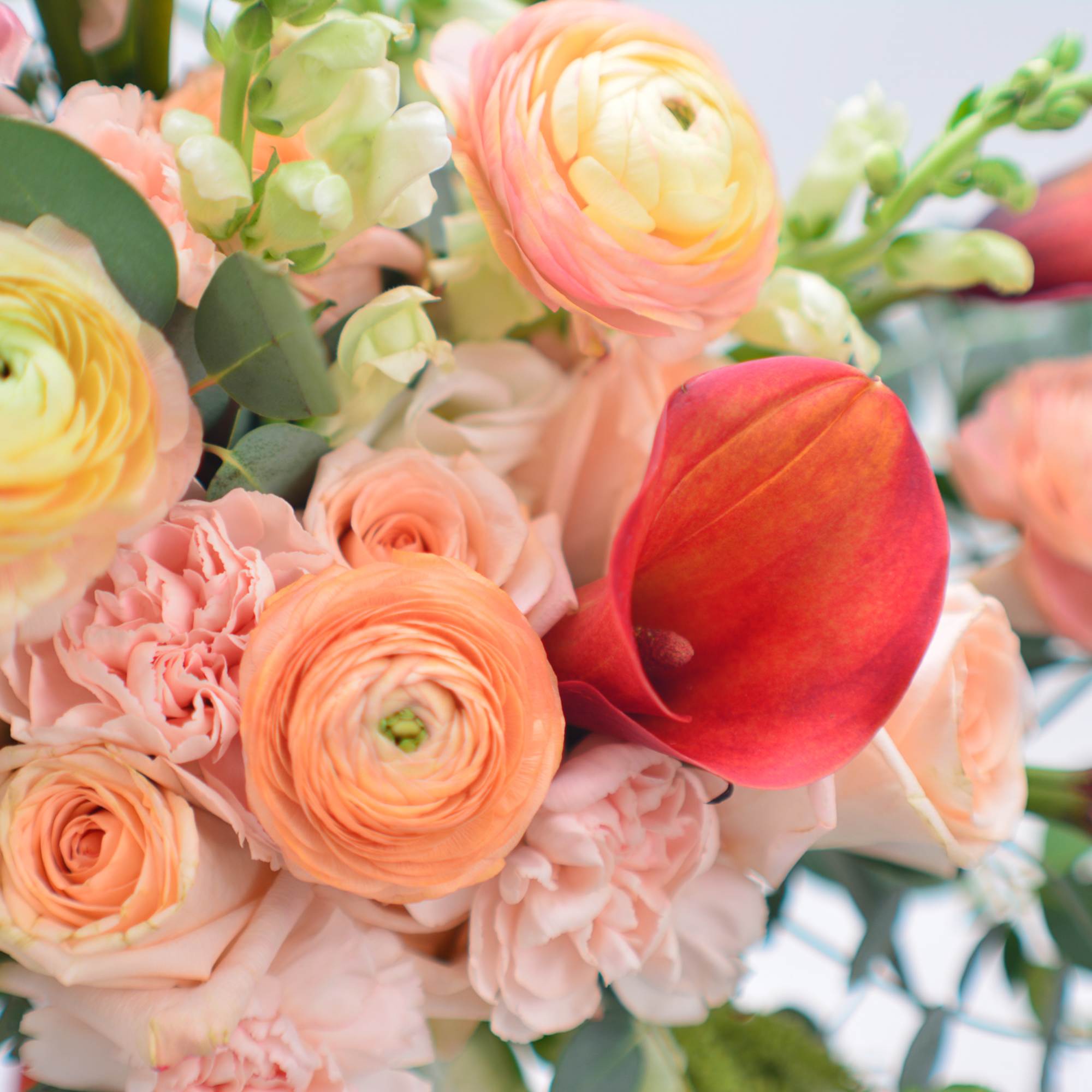 Bouquet of peach and pink flowers with red calla lilies