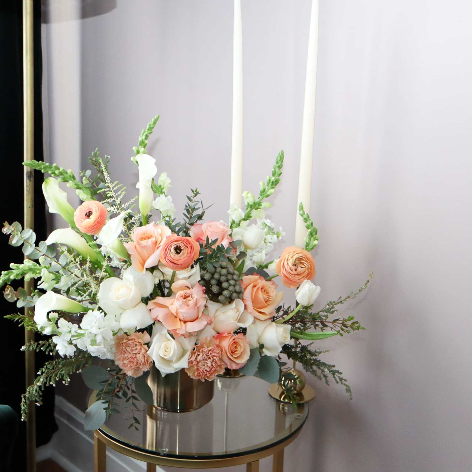 Peach and white floral arrangement in a metallic vase